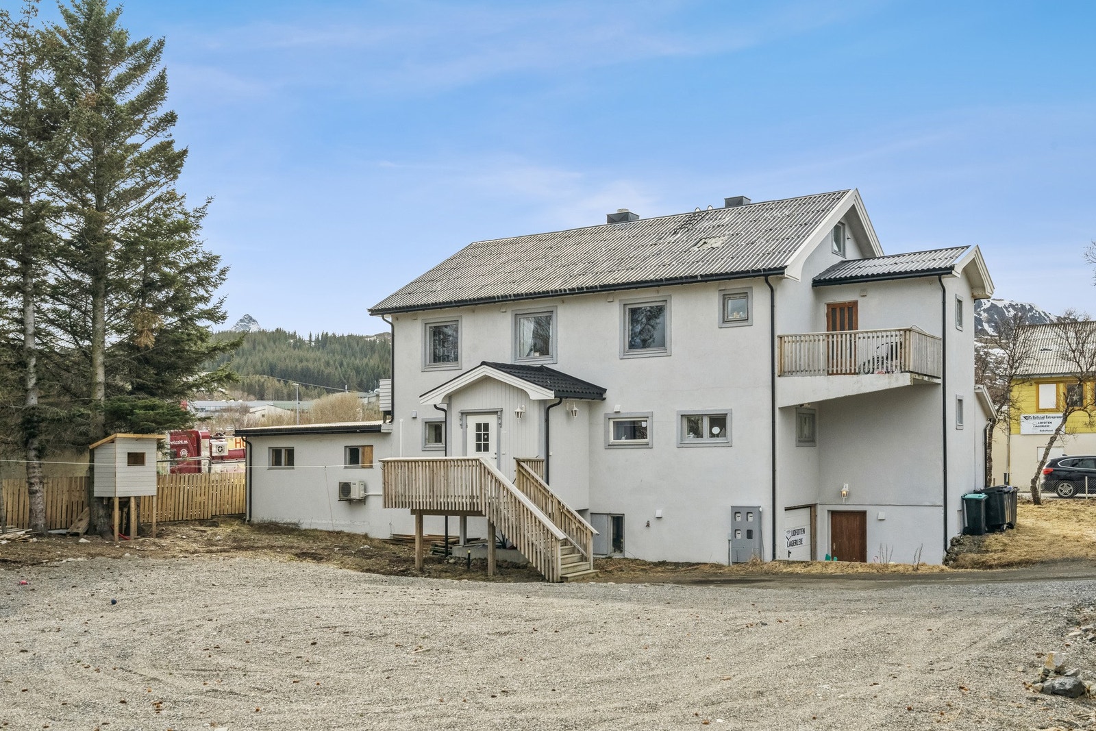 Inngang på baksiden av bygget til leiligheten som ligger i 1. etasjen. Nyere garasjeport ned til kjelleren hvor bodene er. Galleribilde