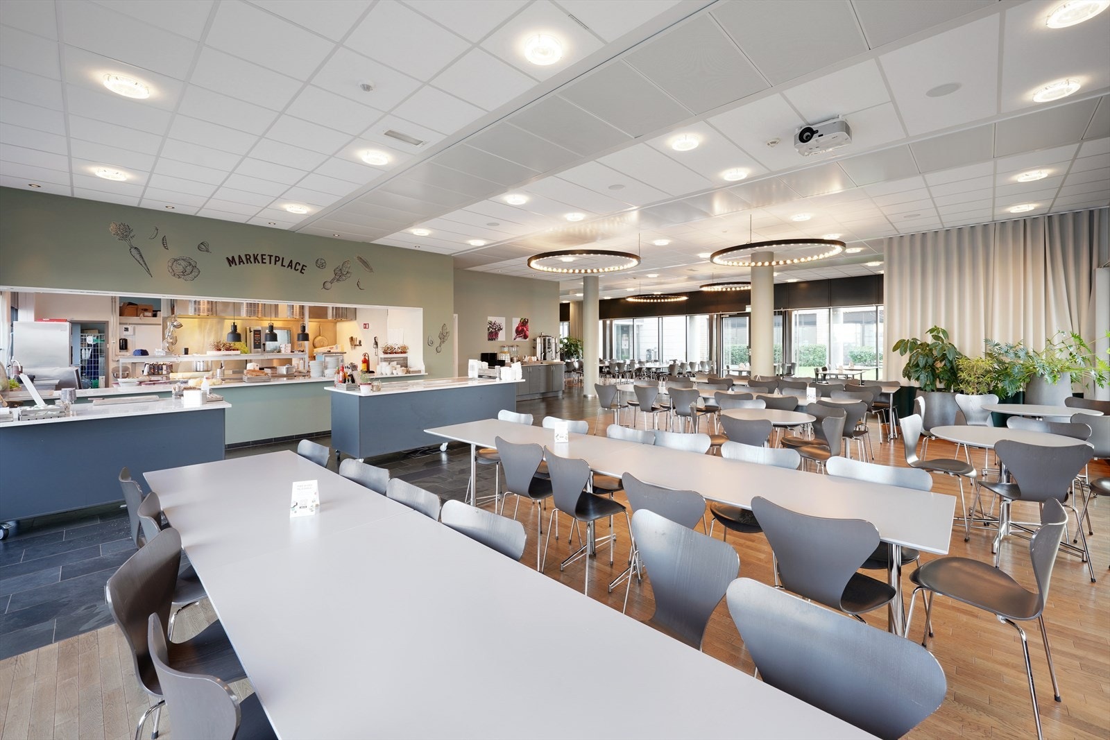 Romslig og moderne kantine med rikelig sitteplasser, ideelt for sosiale sammenkomster eller avslappende pauser. Galleribilde