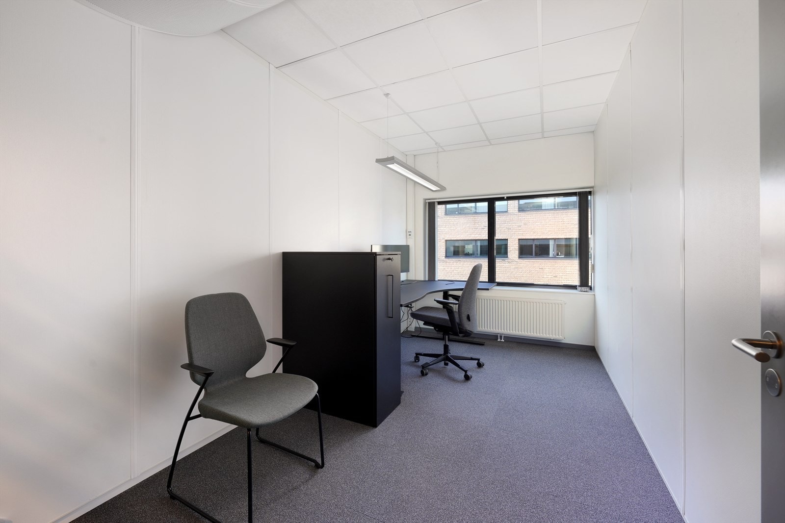 Lyst og moderne kontorlokale med store vinduer som gir rikelig med naturlig lys. Galleribilde