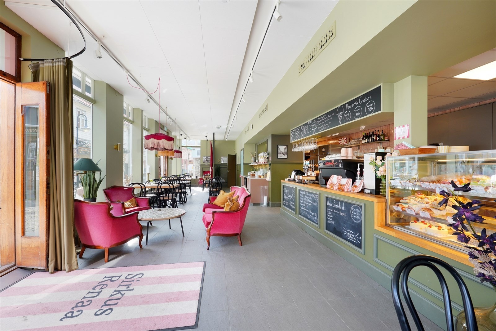 Lys og innbydende kafé med rikelig sitteplass og en sjarmerende atmosfære, ideell for sosiale sammenkomster. Galleribilde