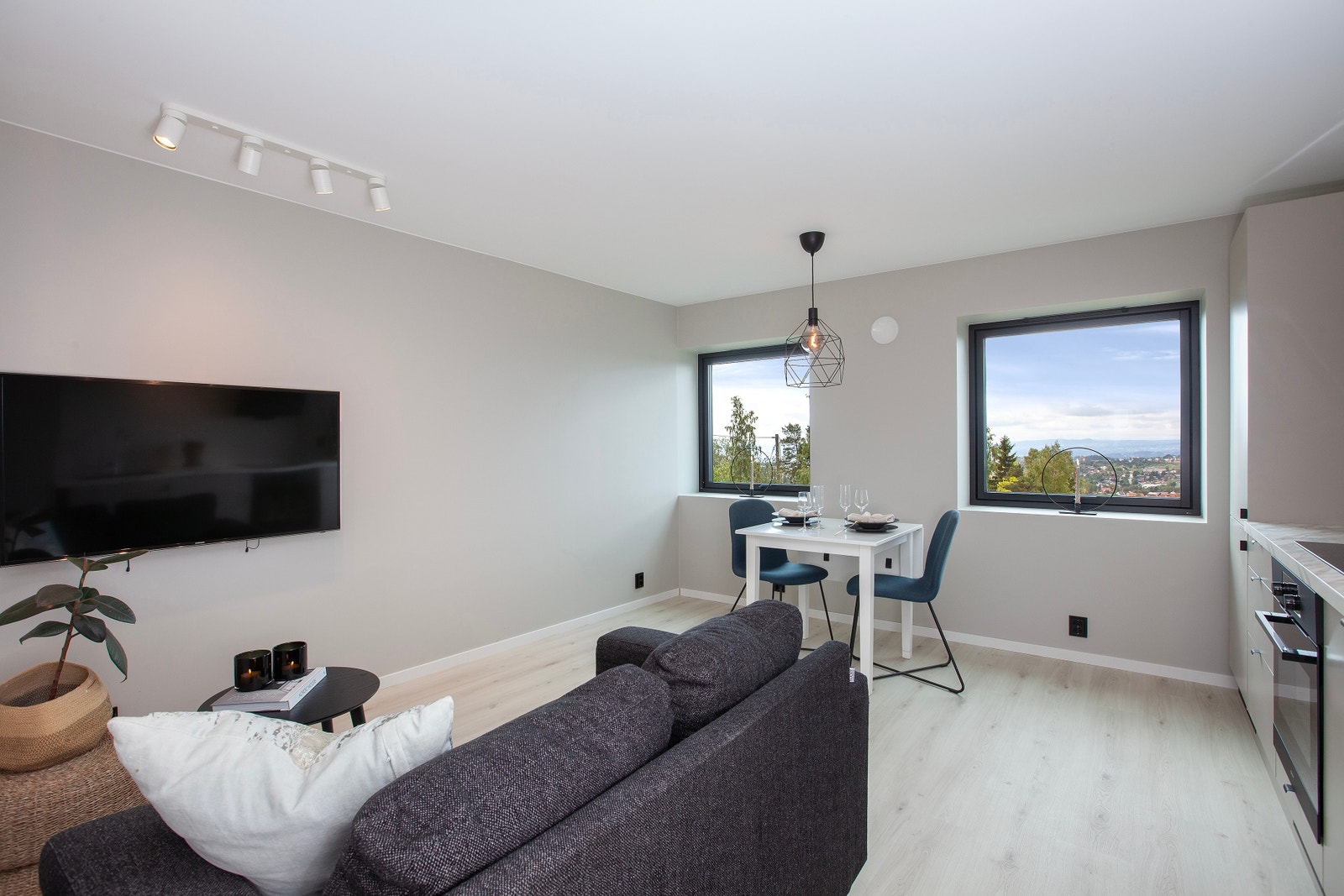 Pen stue/kjøkkenløsning, med spiseplass og sofa m/vegghengt tv Galleribilde