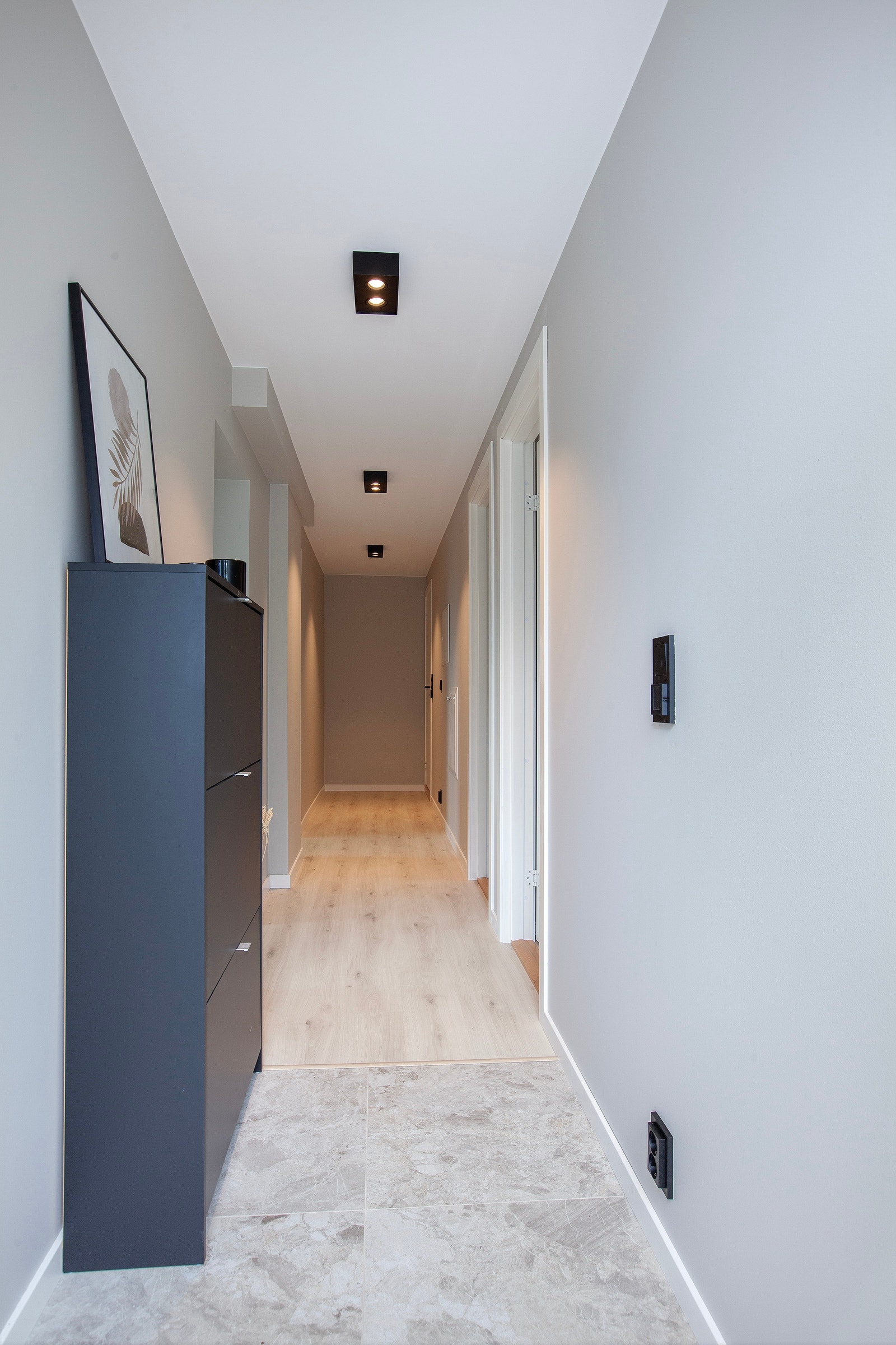 Flislagt inngangsparti med knagger og skohylle Galleribilde