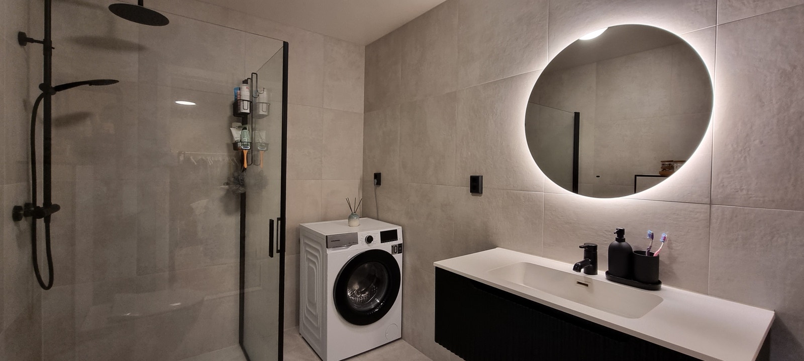 Flott bad med stort dusjkabinett, vaskemaskin og varmekabler i gulvet Galleribilde