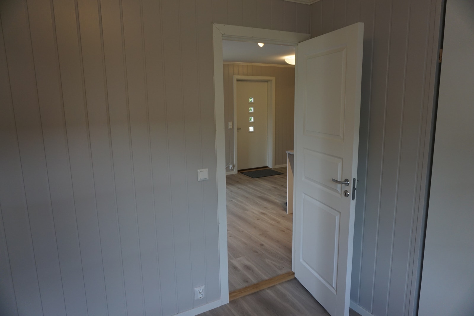 Soverom-2 : Stort soverom med eikepreg laminatgulv, malt smartpanel på vegger. Galleribilde