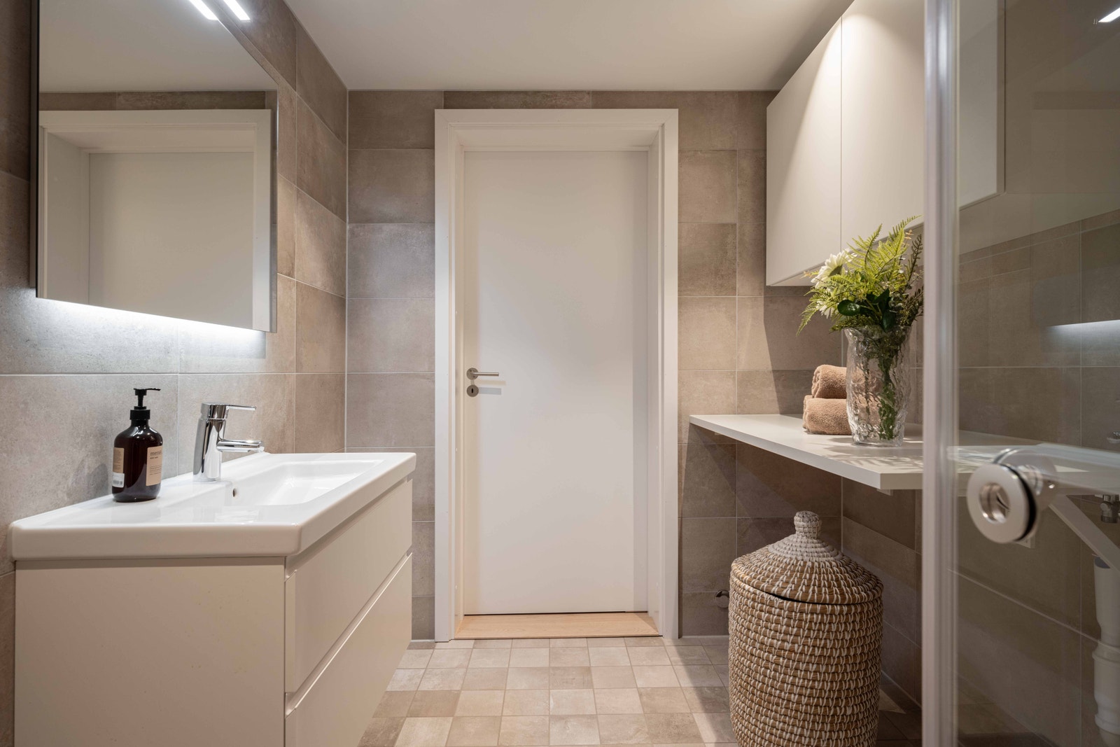 Lekkert og delikat bad. Praktisk benkeløsning med plass for vaskemaskin og tørketrommel ved siden av hverandre. Skap over. Galleribilde