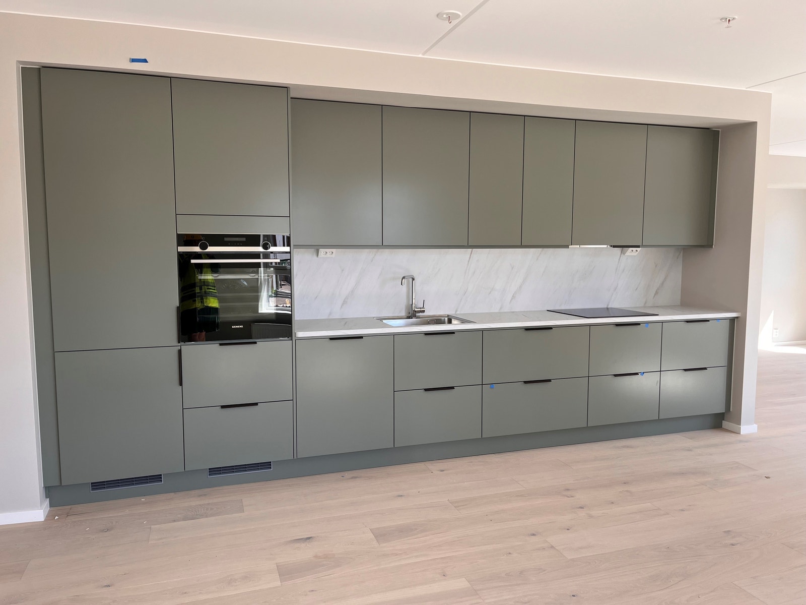 Her er kjøkkenbildet fra 2.etg, leil 1-0203 som har en grønntonet farge på frontene og benkeplate i laminat som heter Modela marmor. Galleribilde