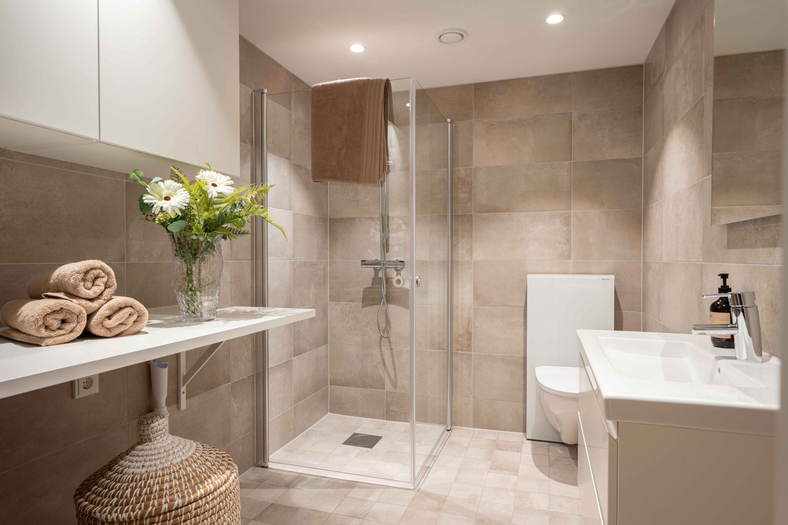 Lekkert og delikat bad. Praktisk benkeløsning med plass for vaskemaskin og tørketrommel ved siden av hverandre. Skap over. Galleribilde