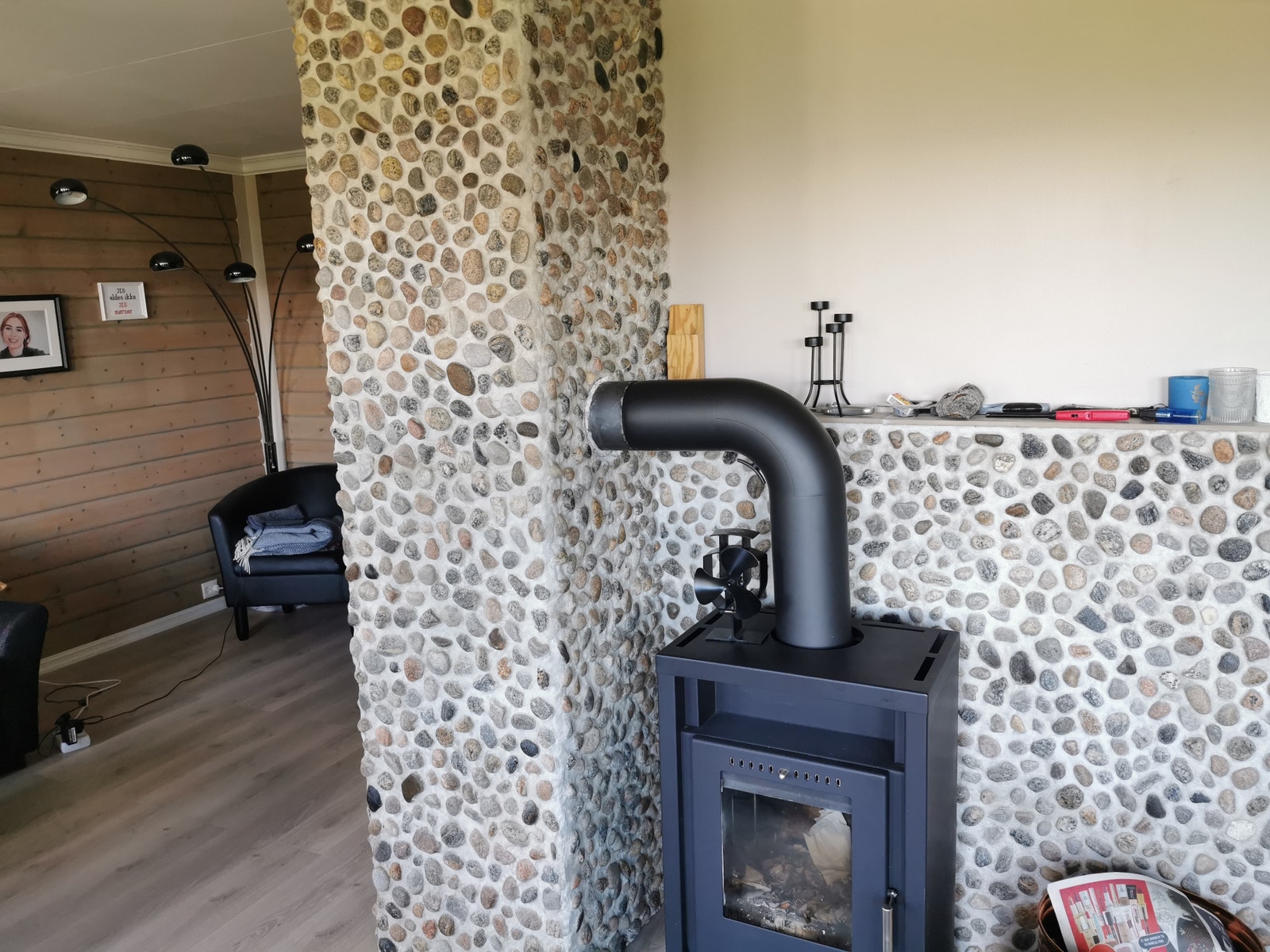 Husets mur i stuen er dekorert med små rullstein plukket lokalt. Galleribilde