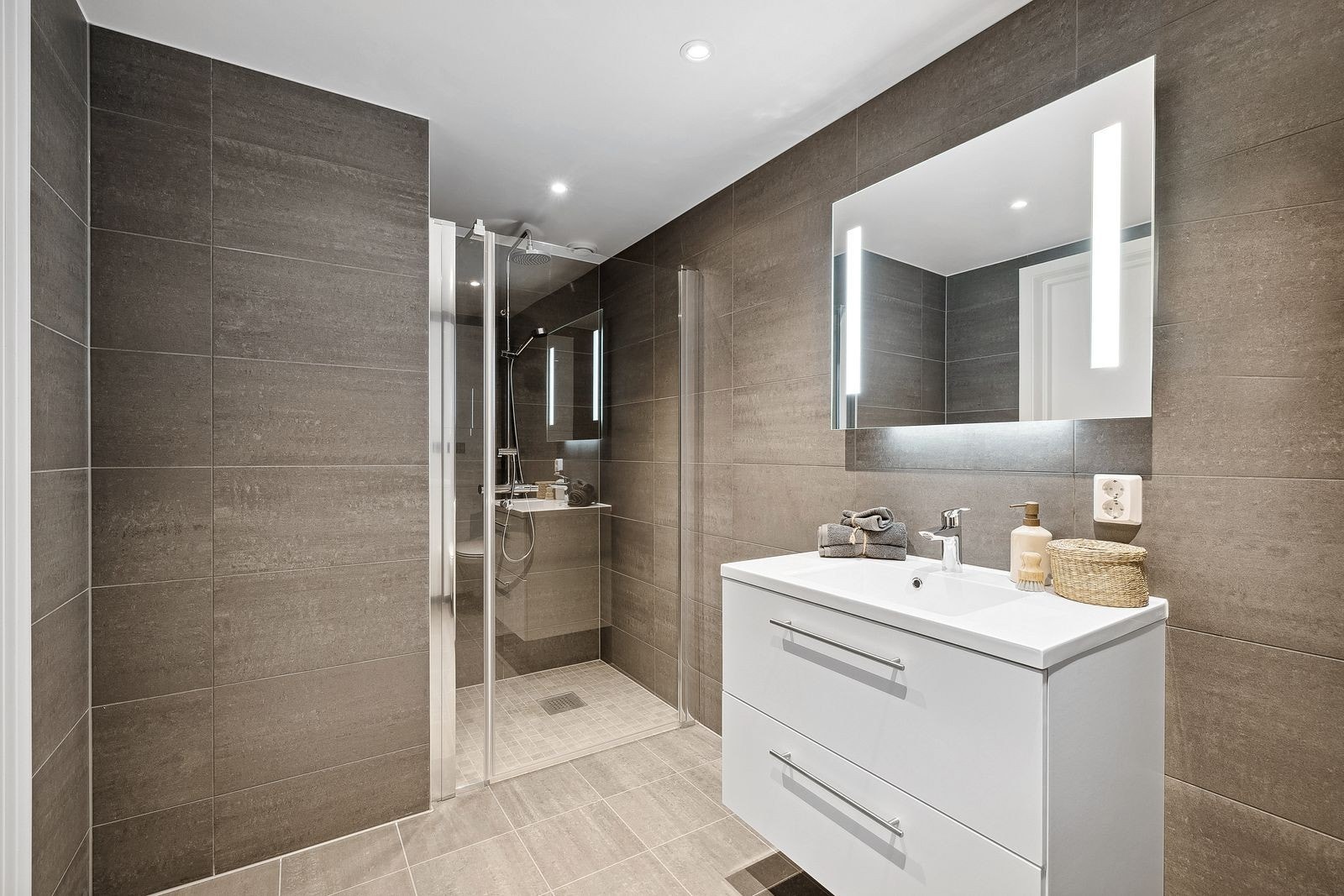 Romslig hovedbad med dusj og opplegg for vaskemaskin. Galleribilde