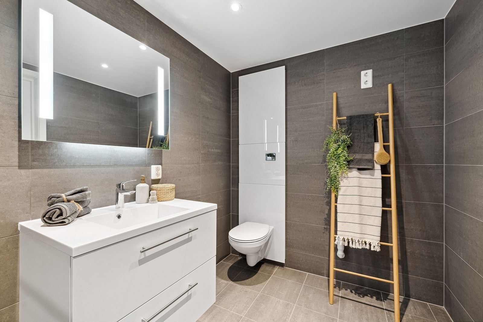 Veggfestet wc. Down-lights i himling og pene fliser. Galleribilde