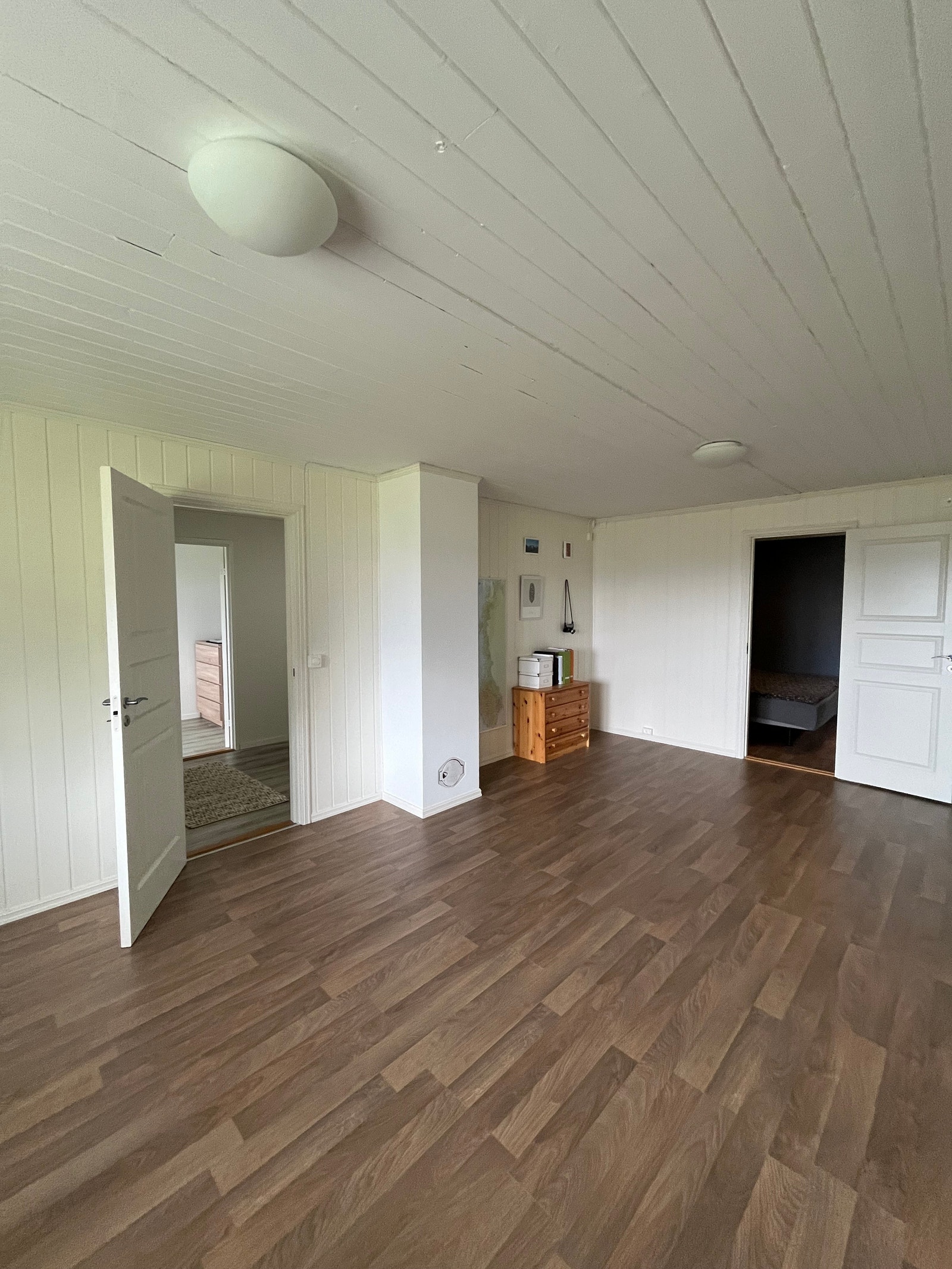 Kjellerstue med dør til kjellergang til venstre og dør til stort soverom i kjelleren til høyre. Galleribilde