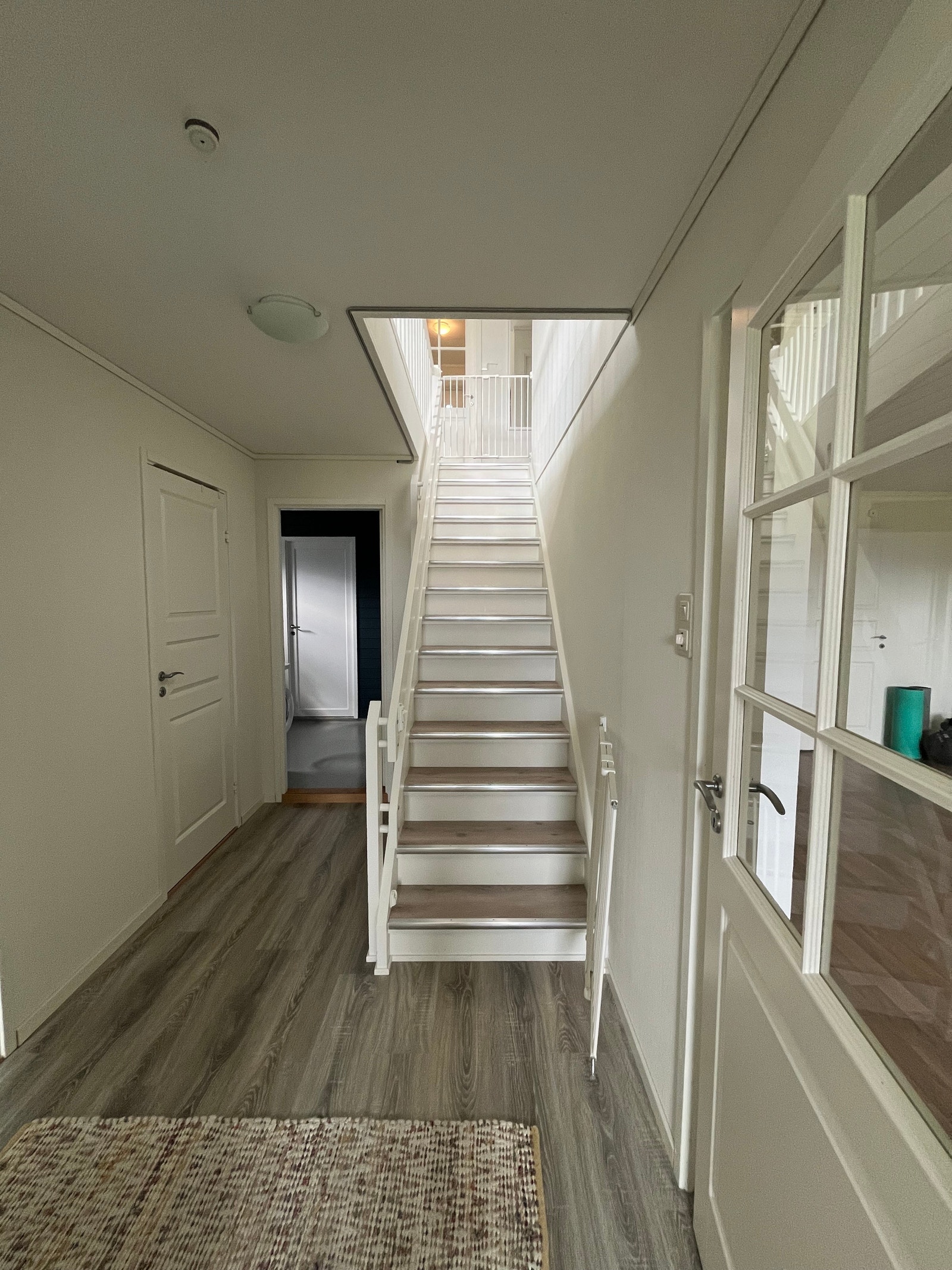 Trapp mellom kjelleren og første etasje sett fra kjellergang. Vaskerom og dør til toalett ses til venstre , kjellerstue til høyre. Galleribilde