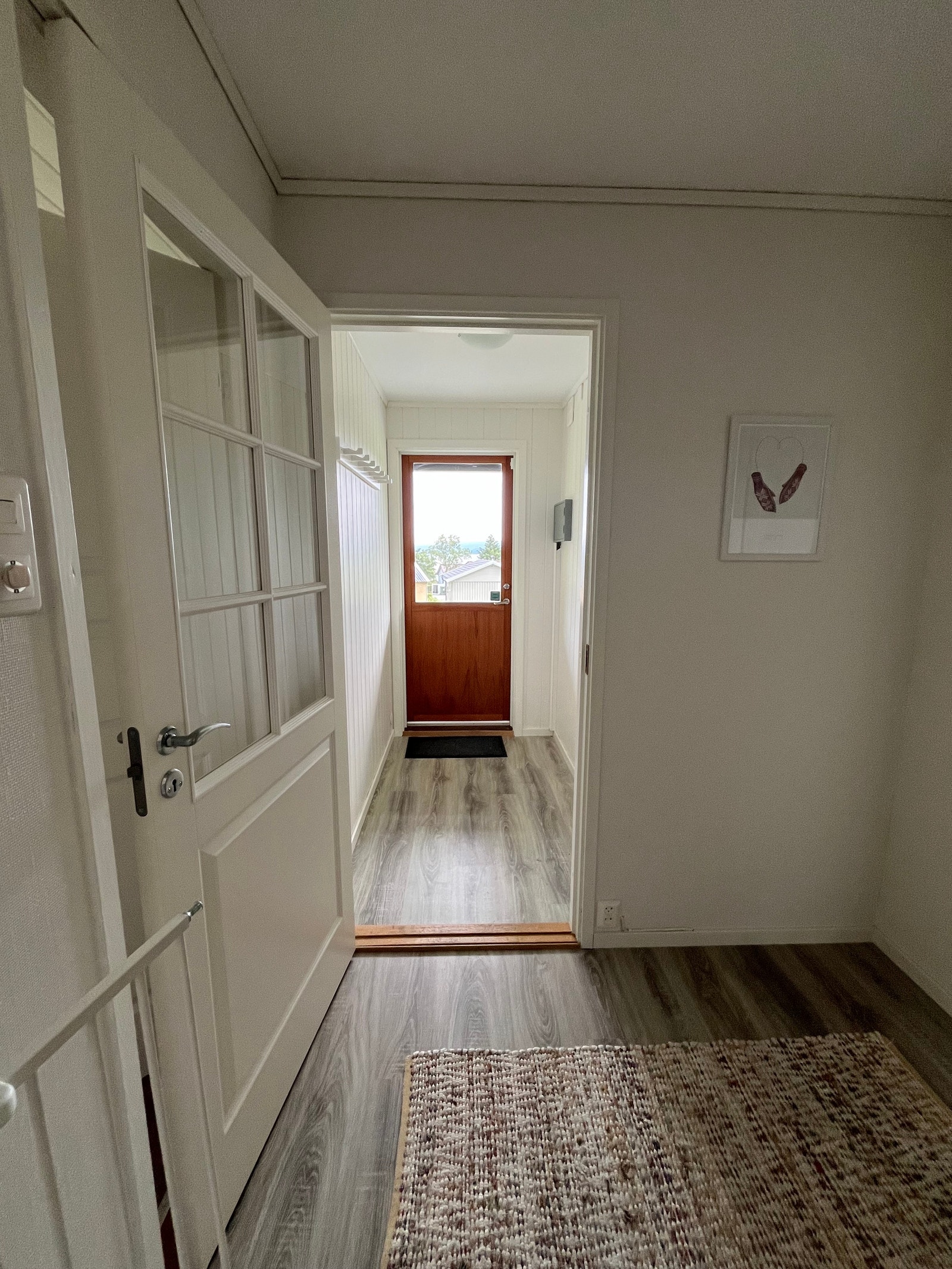 Kjellerdør og -gang sett fra bunnen av trappa. Her går man rett ut til oppgruset uteområde med bålpanne og benker. Galleribilde