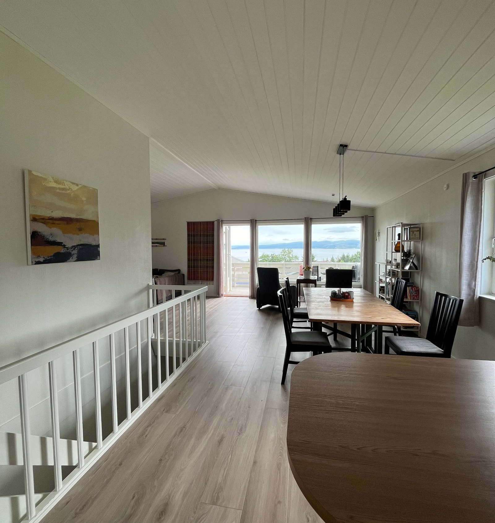 Stue/spisestue sett fra kjøkkenet. Mye lys kommer inn gjennom de store, sørvendte vinduene, stor takhøyde gir et åpent og trivelig rom. Galleribilde