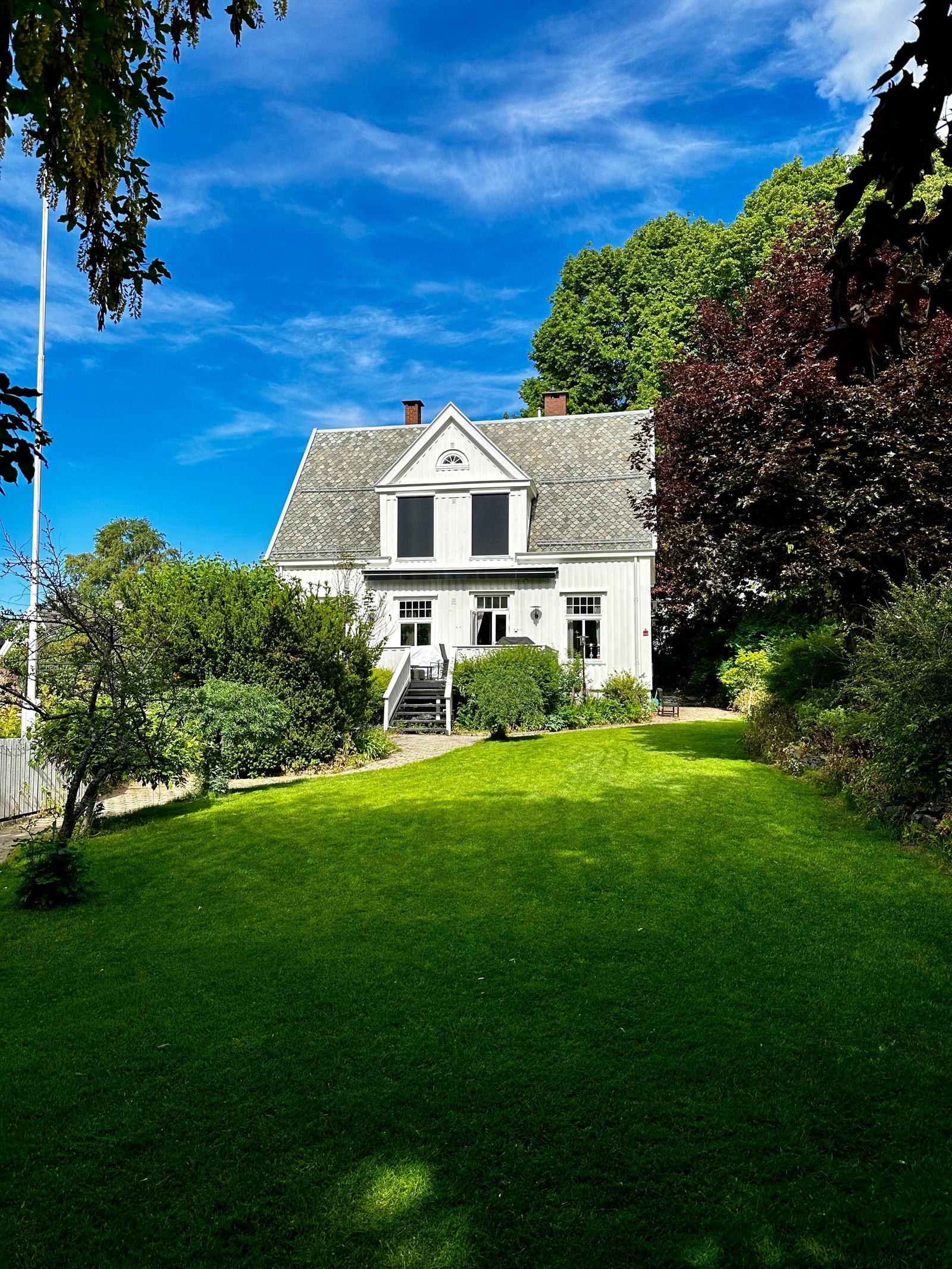 Eiendommens fasade. Leietakers tilgang er skjermet bak vegetasjon til venstre for huset. Galleribilde