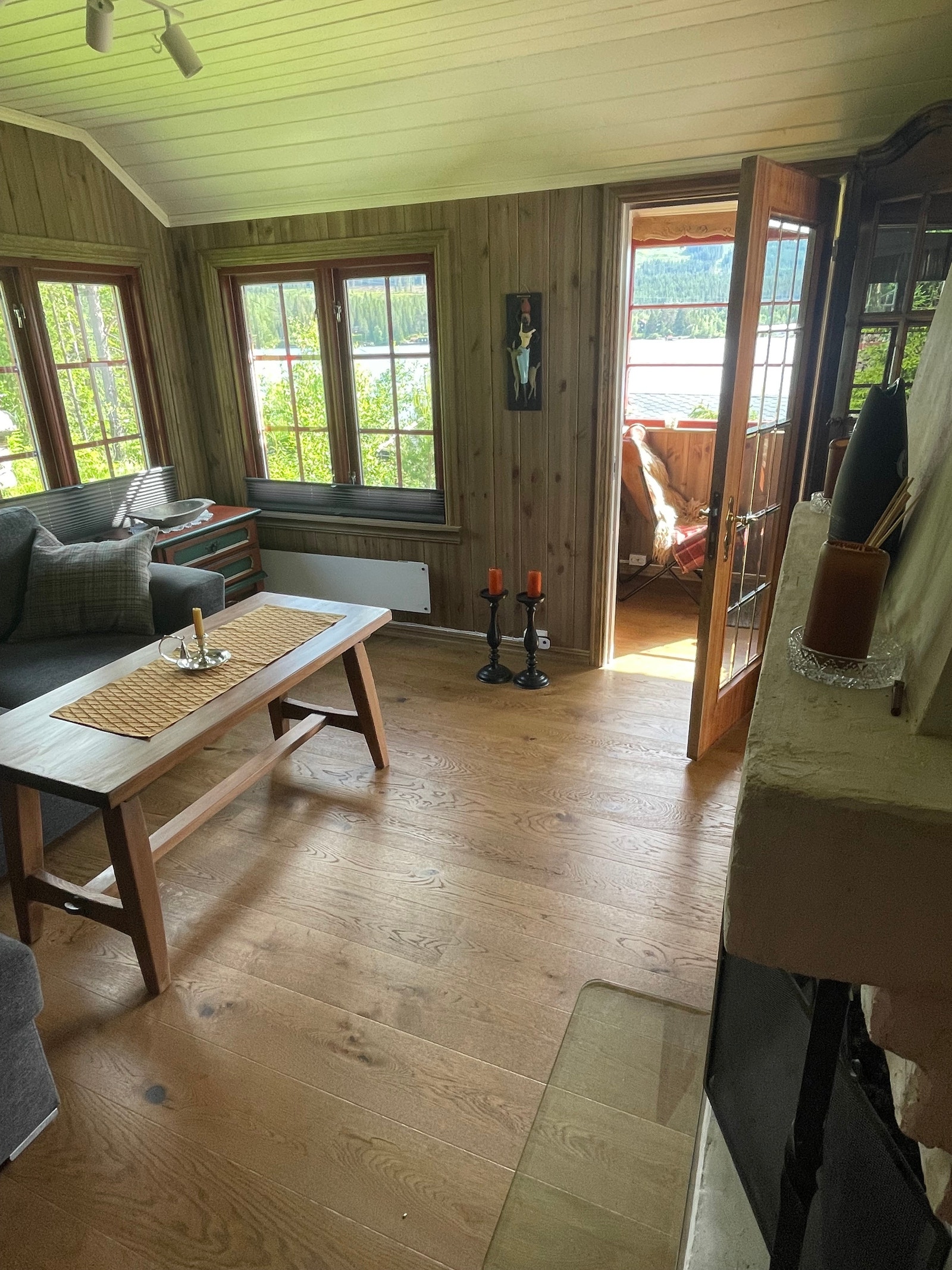 Koselig stue med lavtsittende mange vindu slik at utsikten blir flott også fra sofaen Galleribilde