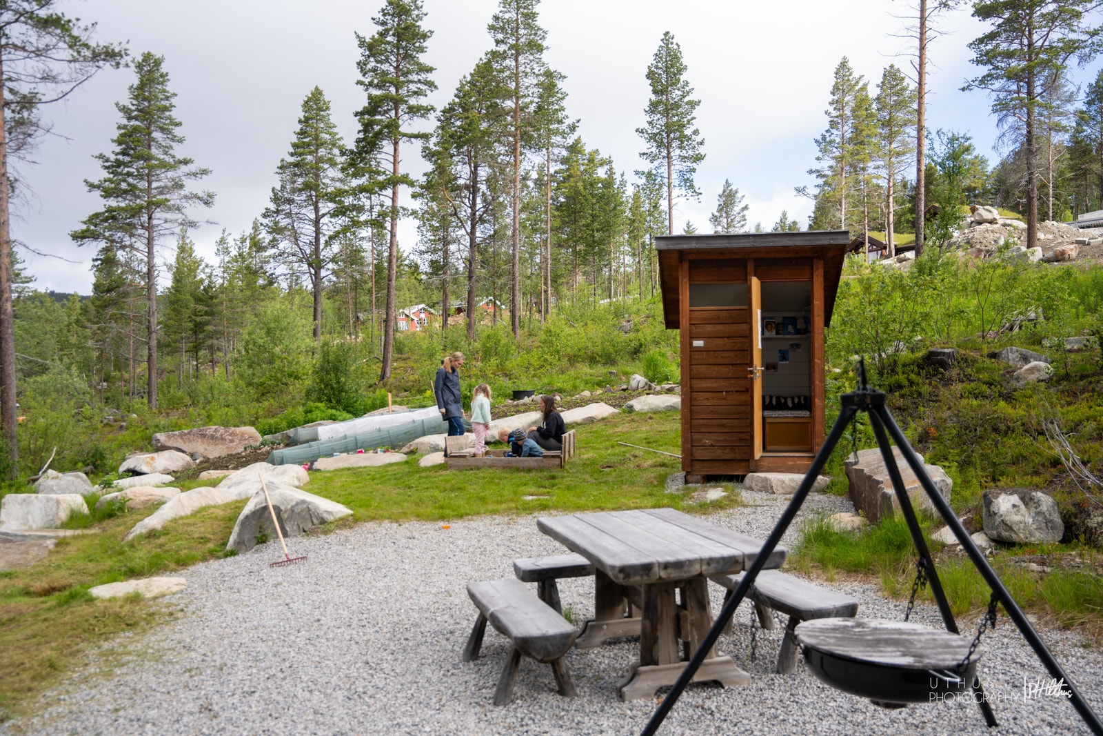 Bord, benker, bålpanne, en liten bokbyttebu og andelsåker gjør fellesområdet i boligfeltet til et sosialt møtested Galleribilde