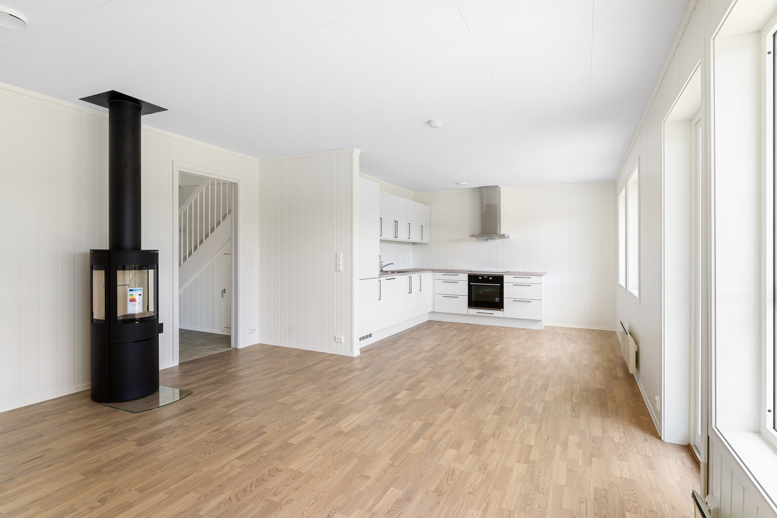 Åpen stue/kjøkkenløsning med vedovn. Galleribilde