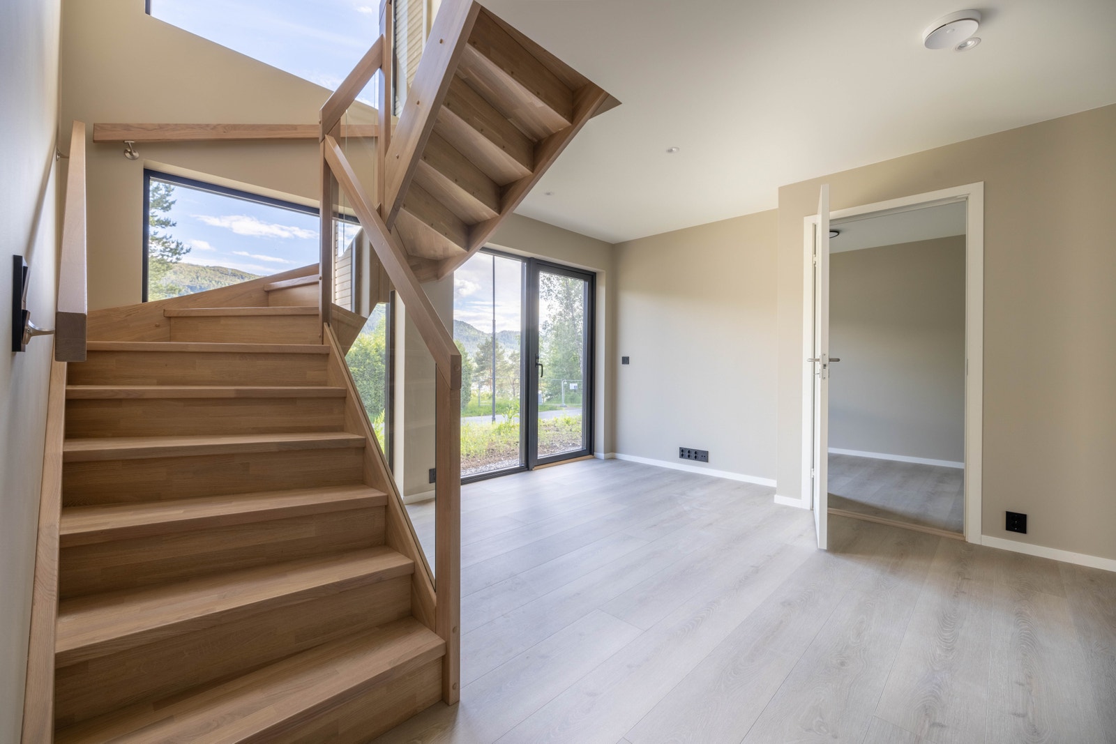 Fin trapp frå Stryntrappa med rekkverk i glas og trinn og handlist i kvitlasert eik. Galleribilde