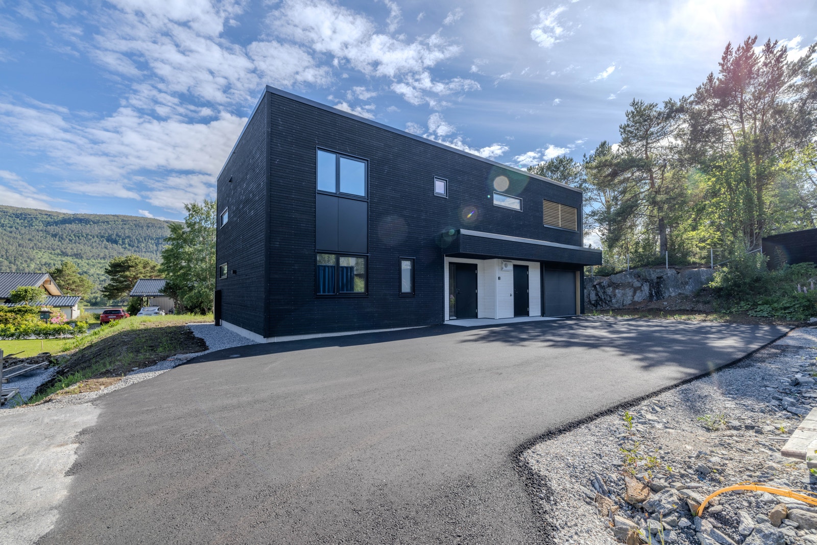 Asfaltert veg og parkeringsareal med god plass til både eigne bilar og gjestar. Galleribilde