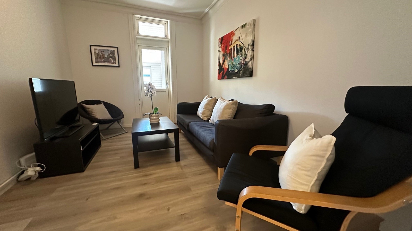 Stue med sofa og stoler. Tv med kanaler Galleribilde