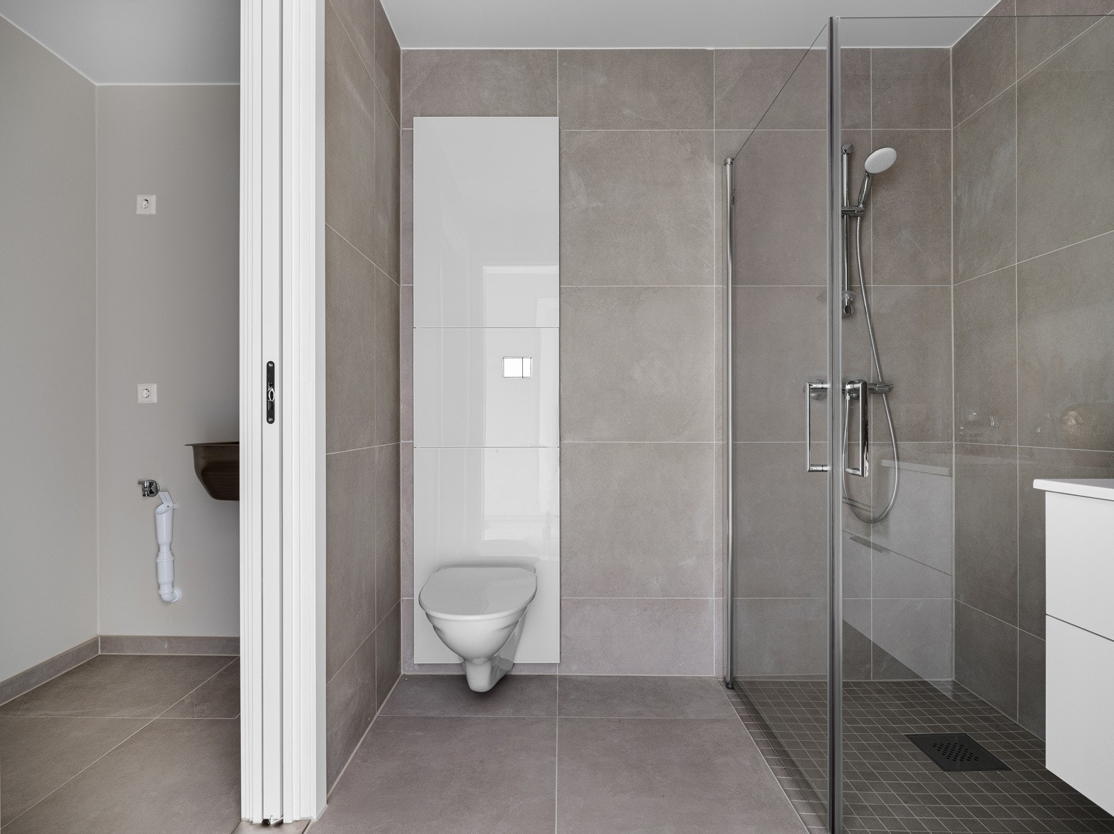 Det andre badet har lik utførelse som hovedbad. Det er såklart gulvvarme. Badet er utstyrt med veggmontert toalett og dusjhjørne med innfellbare dusjdører. Galleribilde