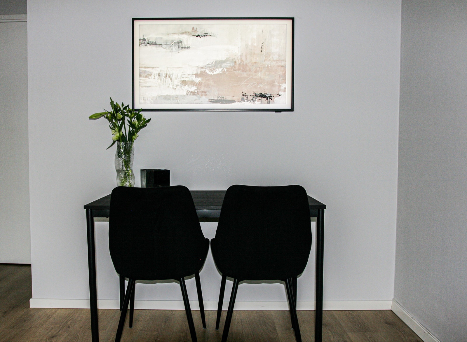 Tv og spisebord med to stoler (Her ser du også veggen som skiller stue fra sovealkoven) Galleribilde