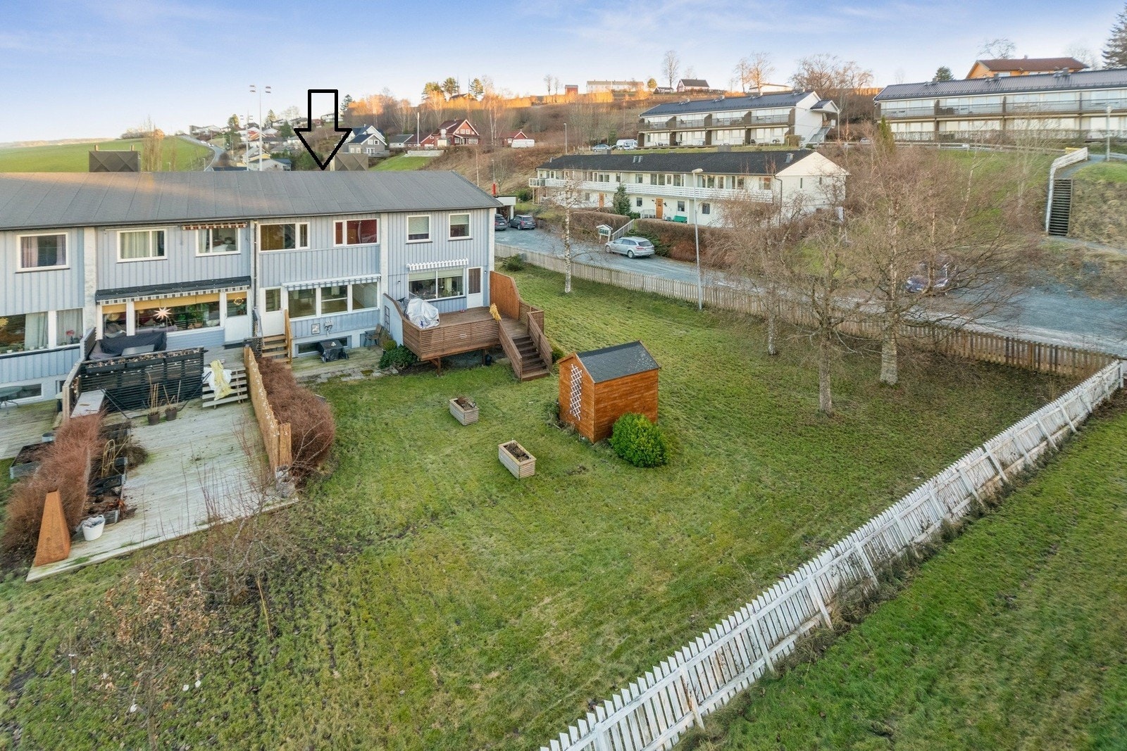 Privat uteområde på baksiden av huset med platting og plen Galleribilde