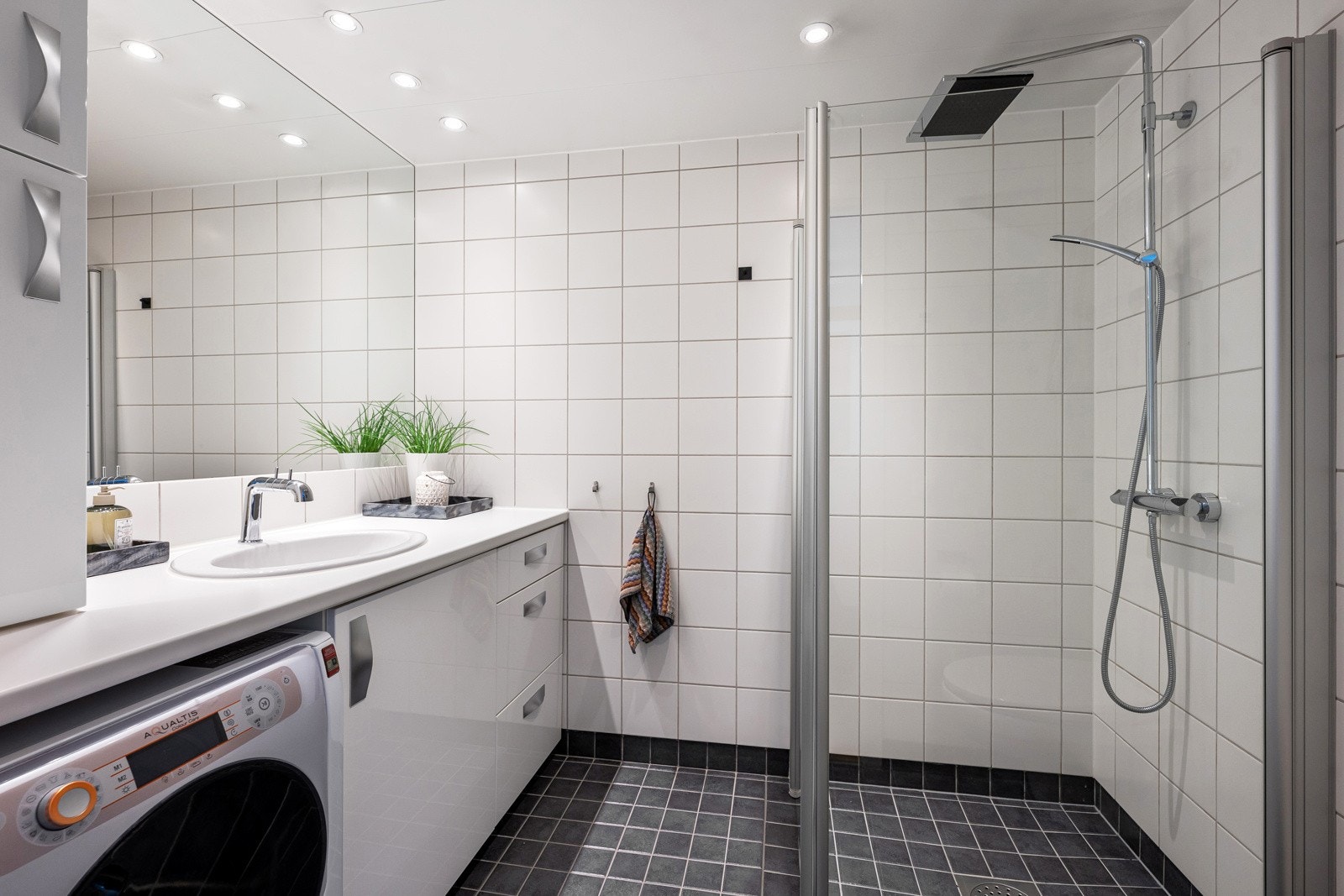 Flislagt baderom fra 2008 med gulvvarme og nedsenket himling med downlights. Baderommet er innredet med servantskap, dusjhjørne og vegghengt toalett. Det er opplegg for vaskemaskin. Galleribilde