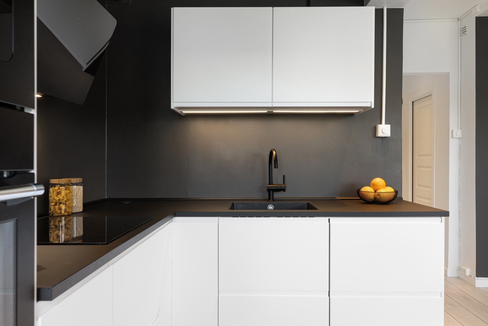 Innredningen fra IKEA har slette fronter og en laminat benkeplate med kompositt oppvaskkum. På kjøkkenet er det en kjøkkenventilator i stål/glass, antatt med kullfilter. Galleribilde