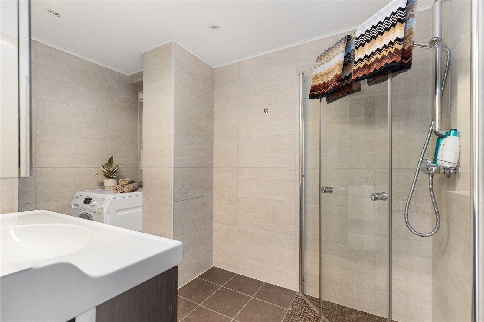 Rommet for velvære er utstyrt med innfellbare dusjdører, mekanisk avtrekk, rørfordelerskap, opplegg for vaskemaskin og servant i skap. Galleribilde