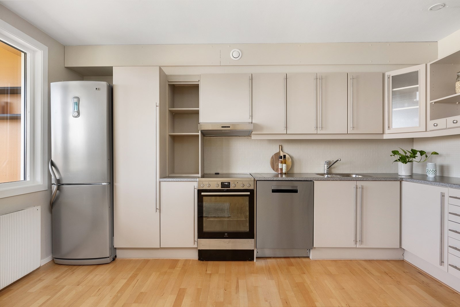 Kjøkkenet ble oppfrisket i 2024 i form av fronter behandlet med en beige fargetone. Her har man et funksjonelt og praktisk kjøkken med slette fronter og gode arbeidssoner. Galleribilde