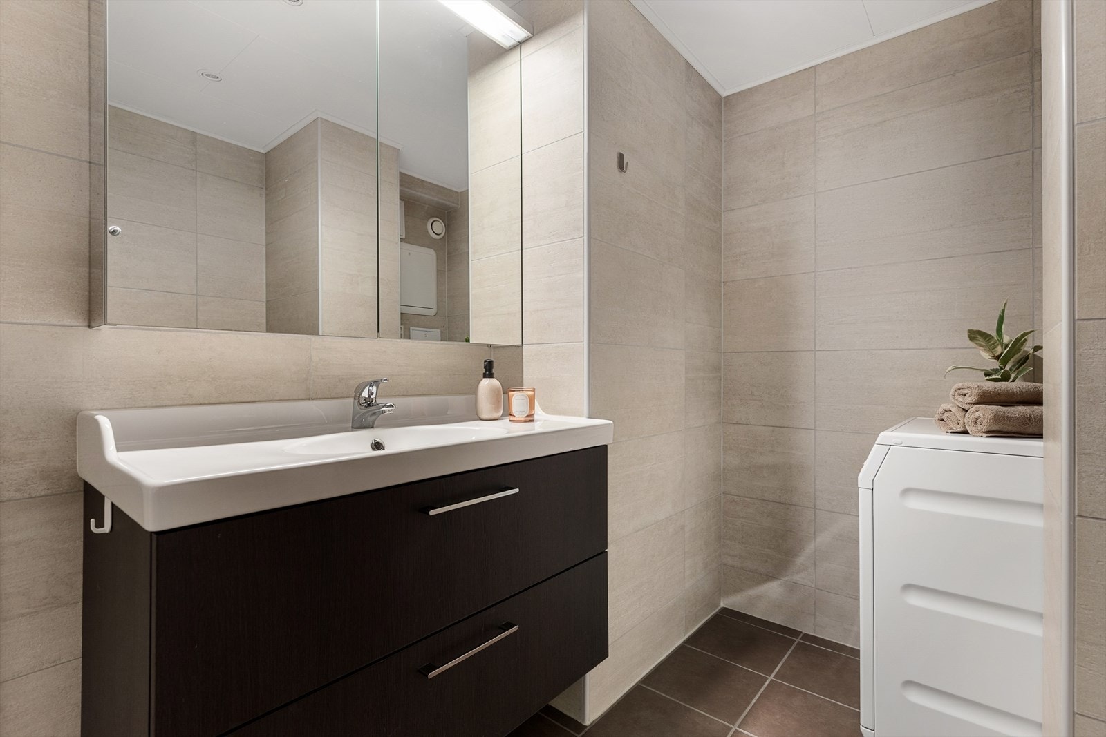 Baderomsinnredningen har god plass til oppbevaring av håndduker og baderomsartikler, og rommet lar seg også innrede med et skap for ekstra lagringsplass. Badet har fått tilstandsgrad 1 i rapport fra takstmann. Galleribilde