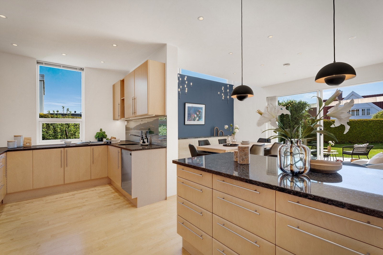 Stilrent kjøkken med åpen løsing mot spisestue. Benkeplate i granitt og bjørkeparkett på gulv gjennomgående i boligen Galleribilde