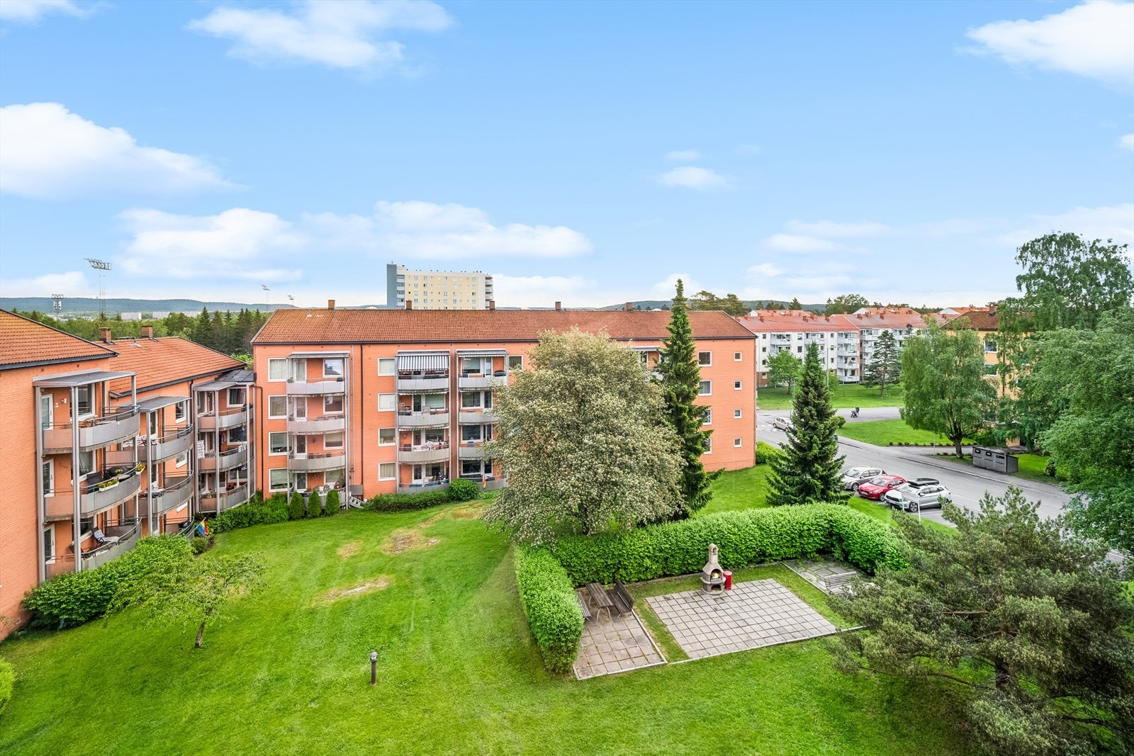 Flott utsyn fra kjøkkenvinduet mot ett av borettslagets grøntområder med sittegruppe og grill. Galleribilde