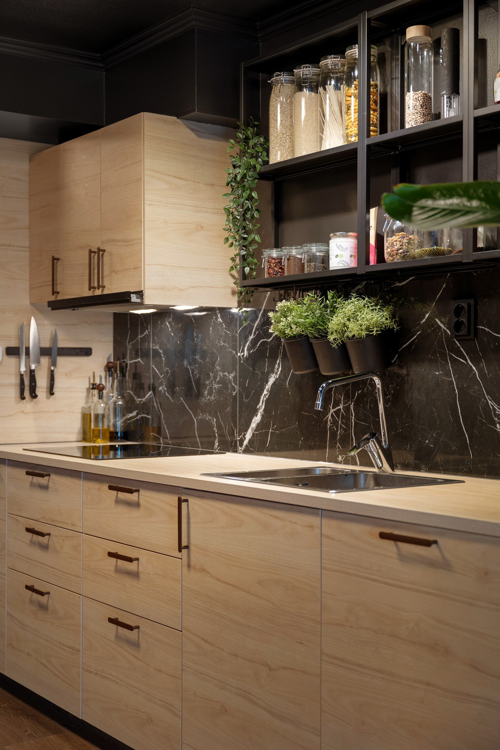 Over benken er veggen beskyttet med store, sorte marmorfliser, og det er montert god arbeidsbelysning i form av spotter og moderne taklamper. Galleribilde