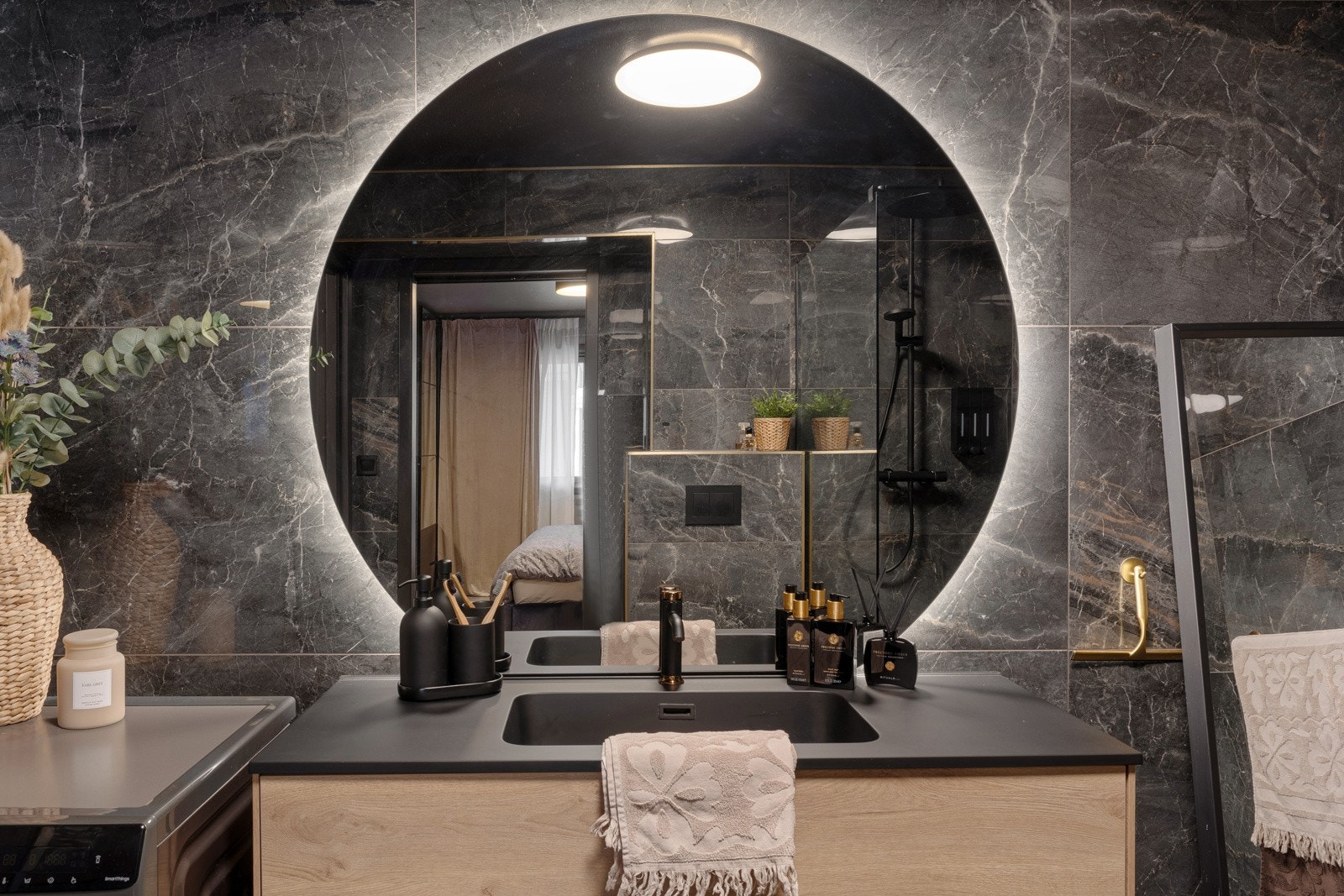 Som en varm kontrast i rommet har baderomsinnredningen gylne eikefronter, og består av en heldekkende, sort servant på en bred skuffeseksjon. Galleribilde