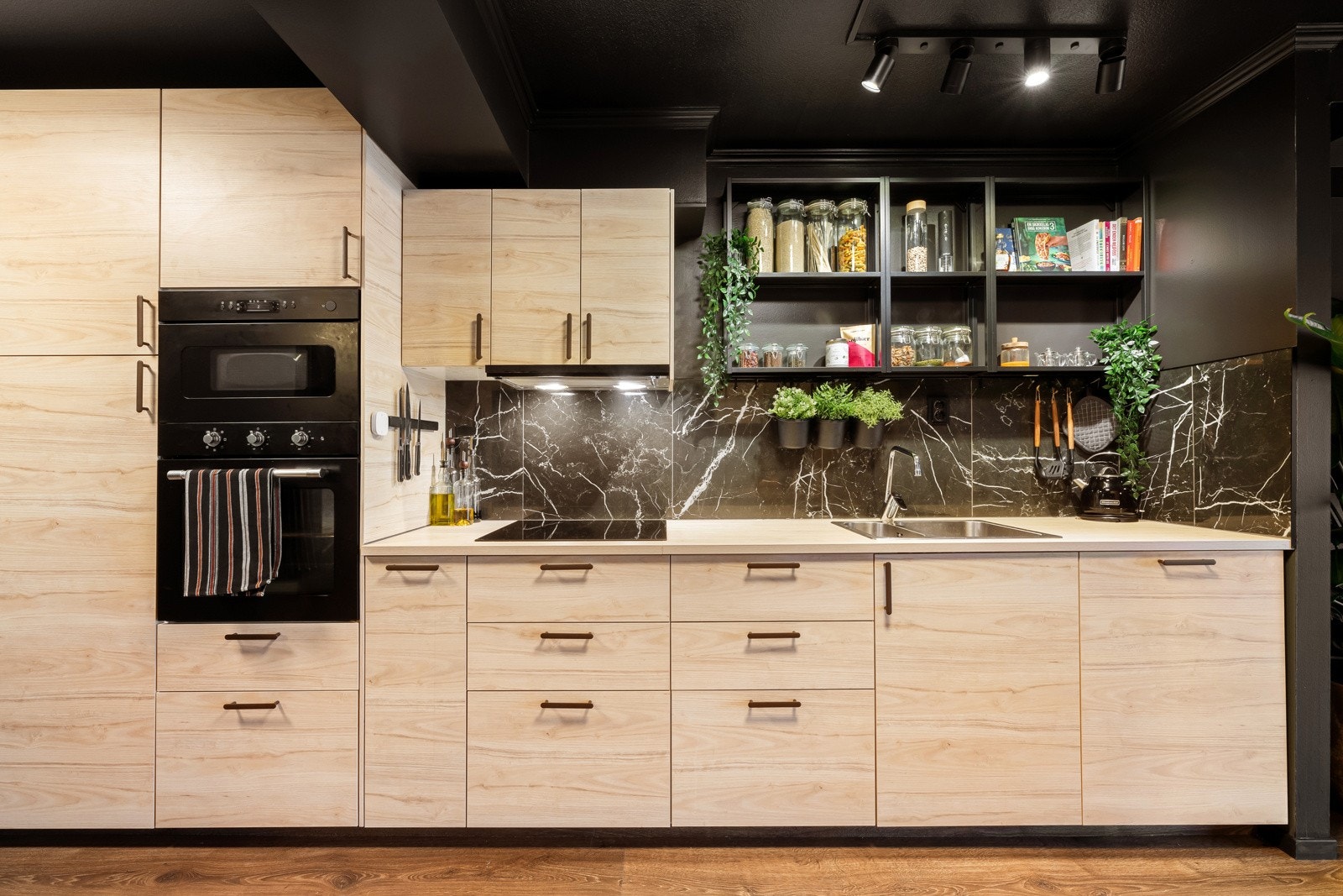 Det er rikelig med oppbevaringsplass i både skuffer og skap, og i en lys laminatbenkeplate er det nedfelt stålkum og integrert kokeplate. Galleribilde