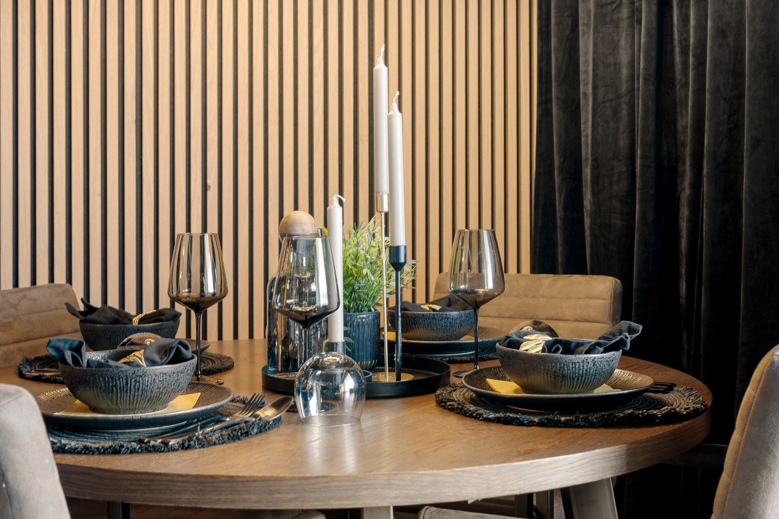 Én av veggene har lyse eikespiler i fin kontrast, og rommet har god plass til en stor sofagruppe og spisebord. Galleribilde