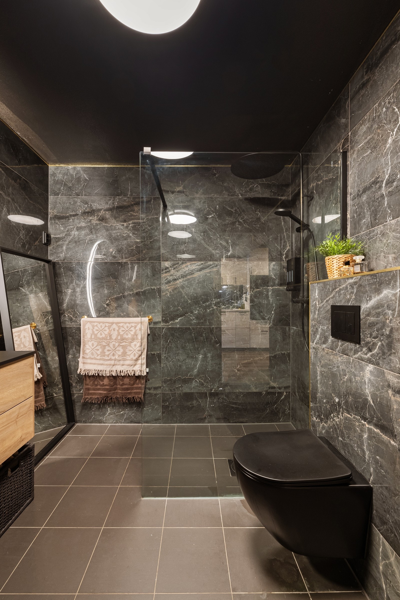 Vegger og gulv er kledd med sorte, blanke marmorfliser som gjenspeiler belysningen på beste måte, og detaljer i gull gir det rette, luksuriøse preget. Galleribilde