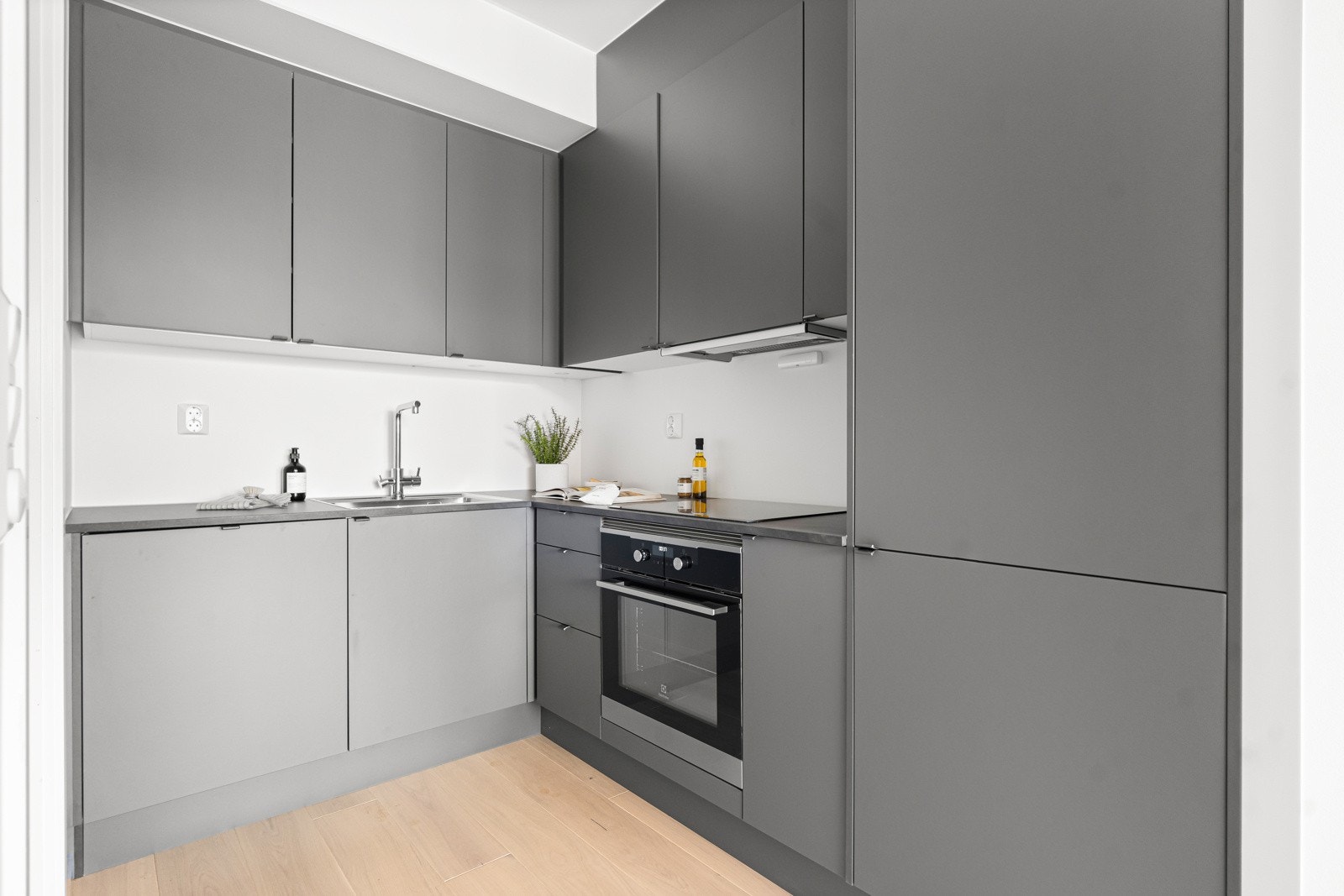 Kjøkkeninnredningen består av glatte fronter med en benkeplate i laminat med kum og ett-greps blandebatteri. Galleribilde