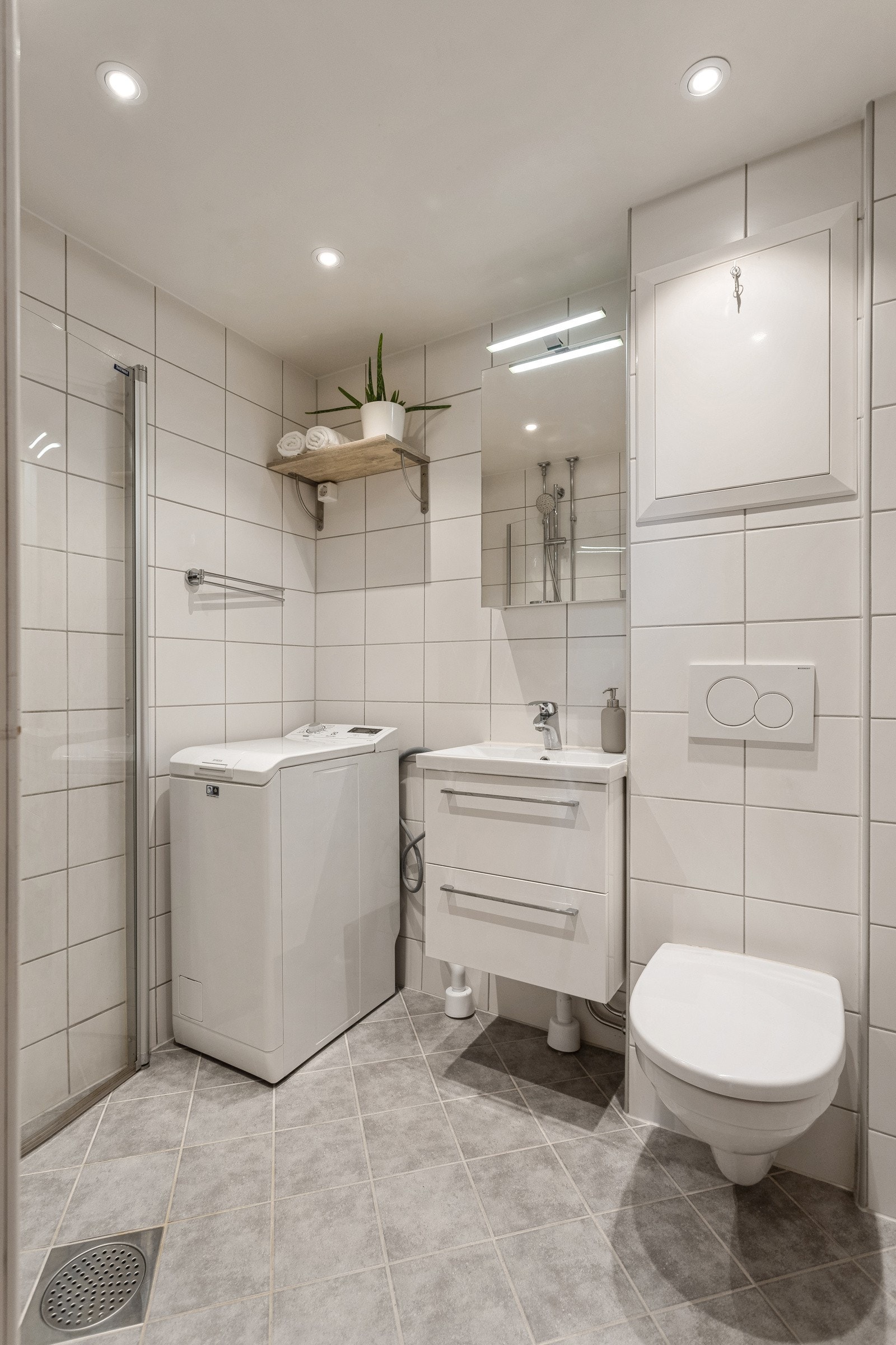 Pent flislagt bad med varmekabler, vendbare dusjvegger, vegg wc og downlights Galleribilde