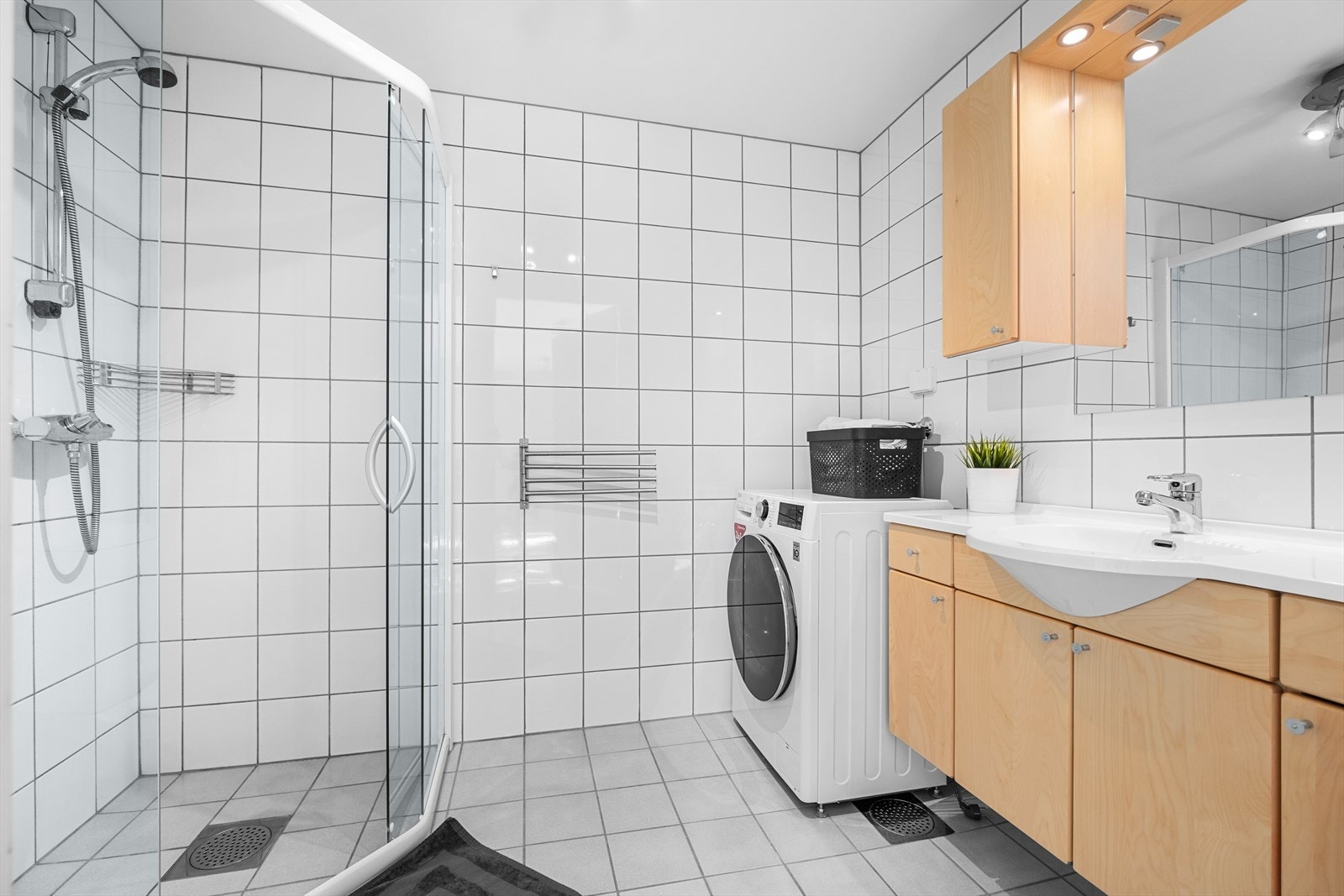 Badet er utstyrt med servant, dusjgarnityr, ferdig opplegg for vaskemaskin og behagelig gulvvarme. Galleribilde