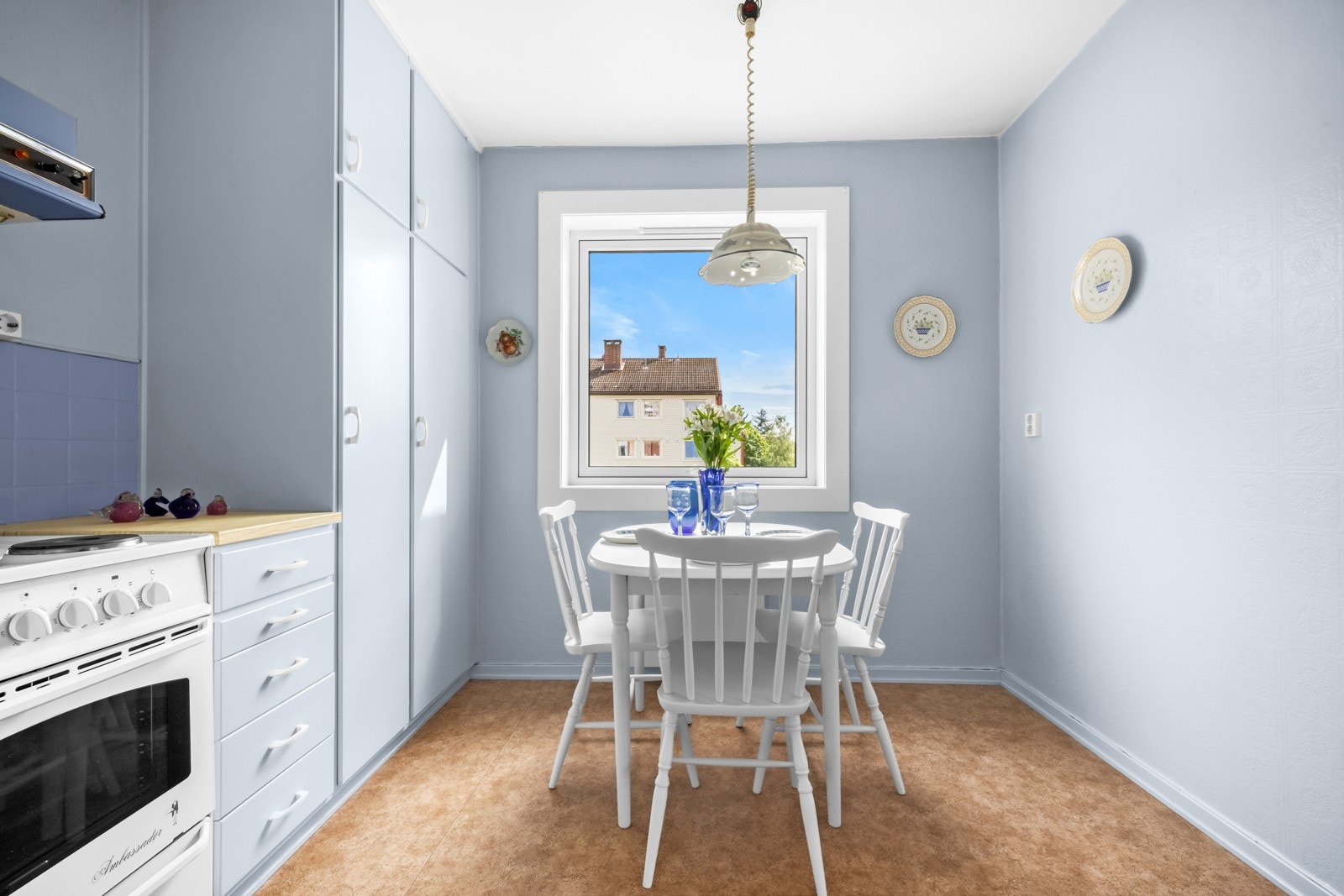 Rommet har vegger malt i samme blåfarge som innredningen, brunt gulvbelegg og glatt, listefri himling. Ved kjøkkenvinduet er det god plass til frokostbord. Galleribilde