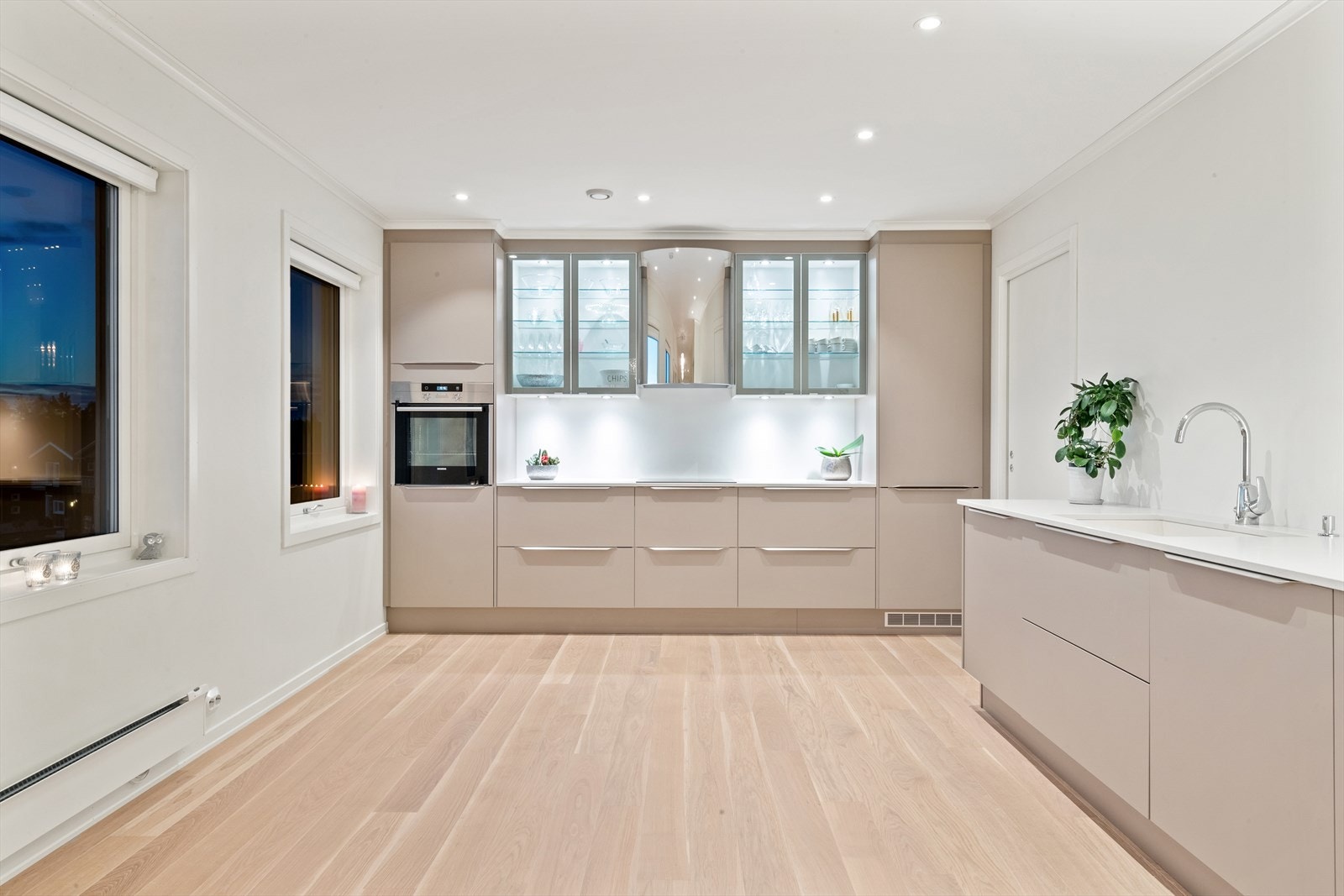 Lekker kjøkkeninnredning med glatte fronter og stenbenkeplate. Fra kjøkkenet er det inngang til praktisk bod. Galleribilde