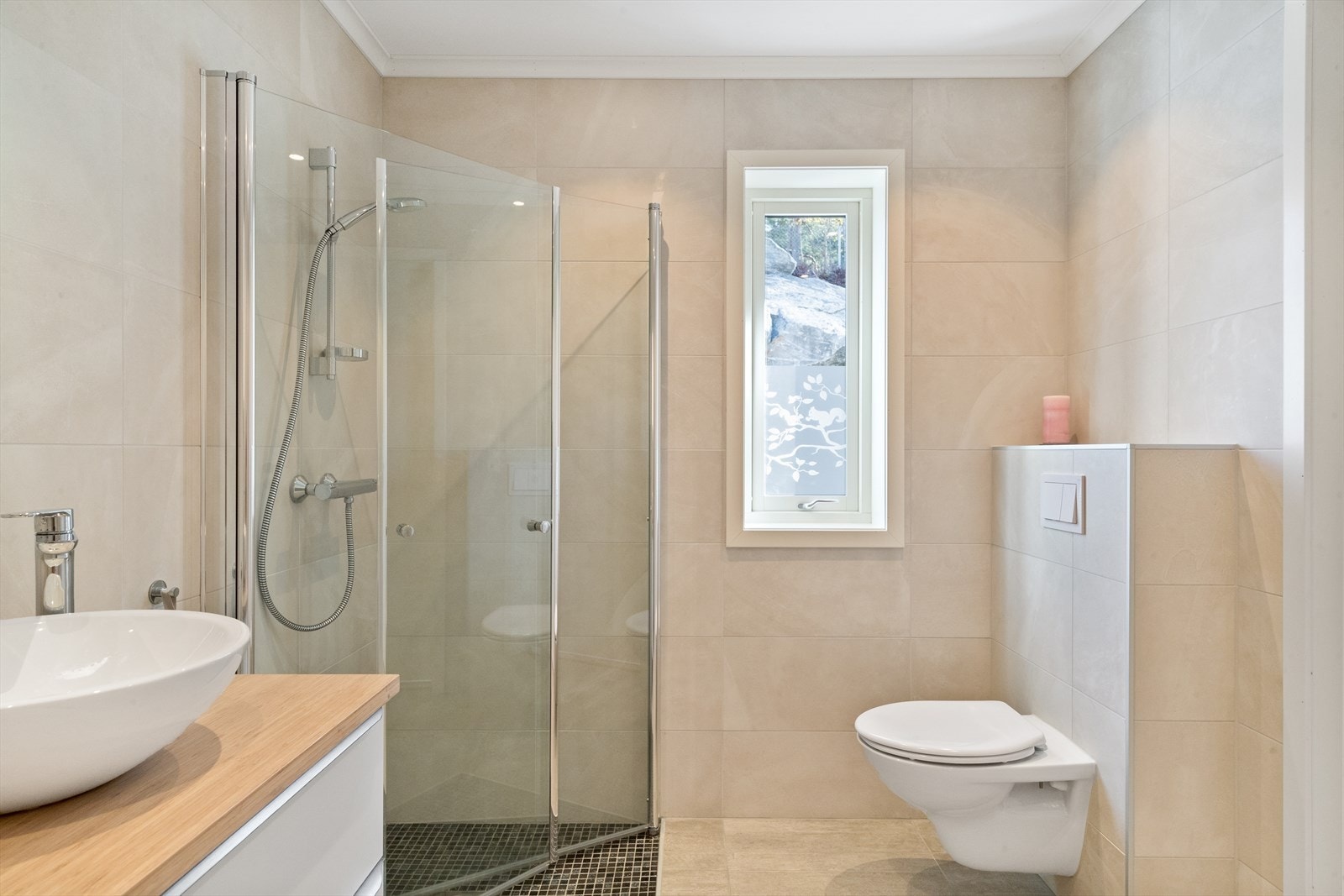 Innredet med servant, underskap, vegghengt toalett og dusjsone med innfellbare dusjvegger. Galleribilde