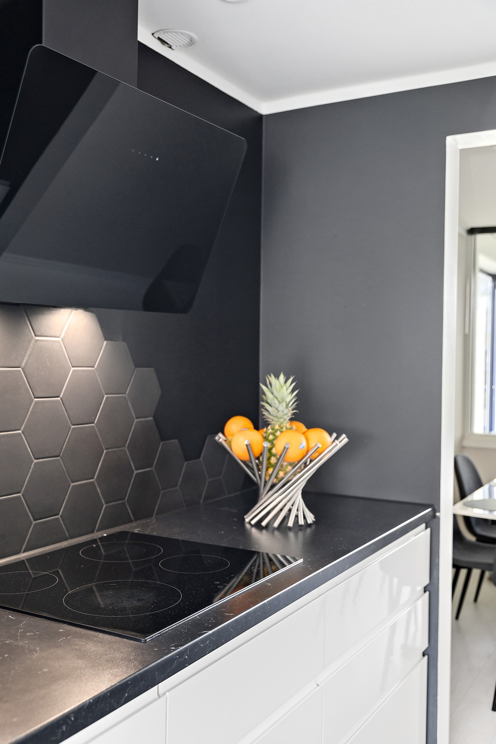 Det er flislagt mellom benkeplate og overskap med et lekkert flisvalg (hexagon mønster) som står i kontrast til innredningen. Galleribilde