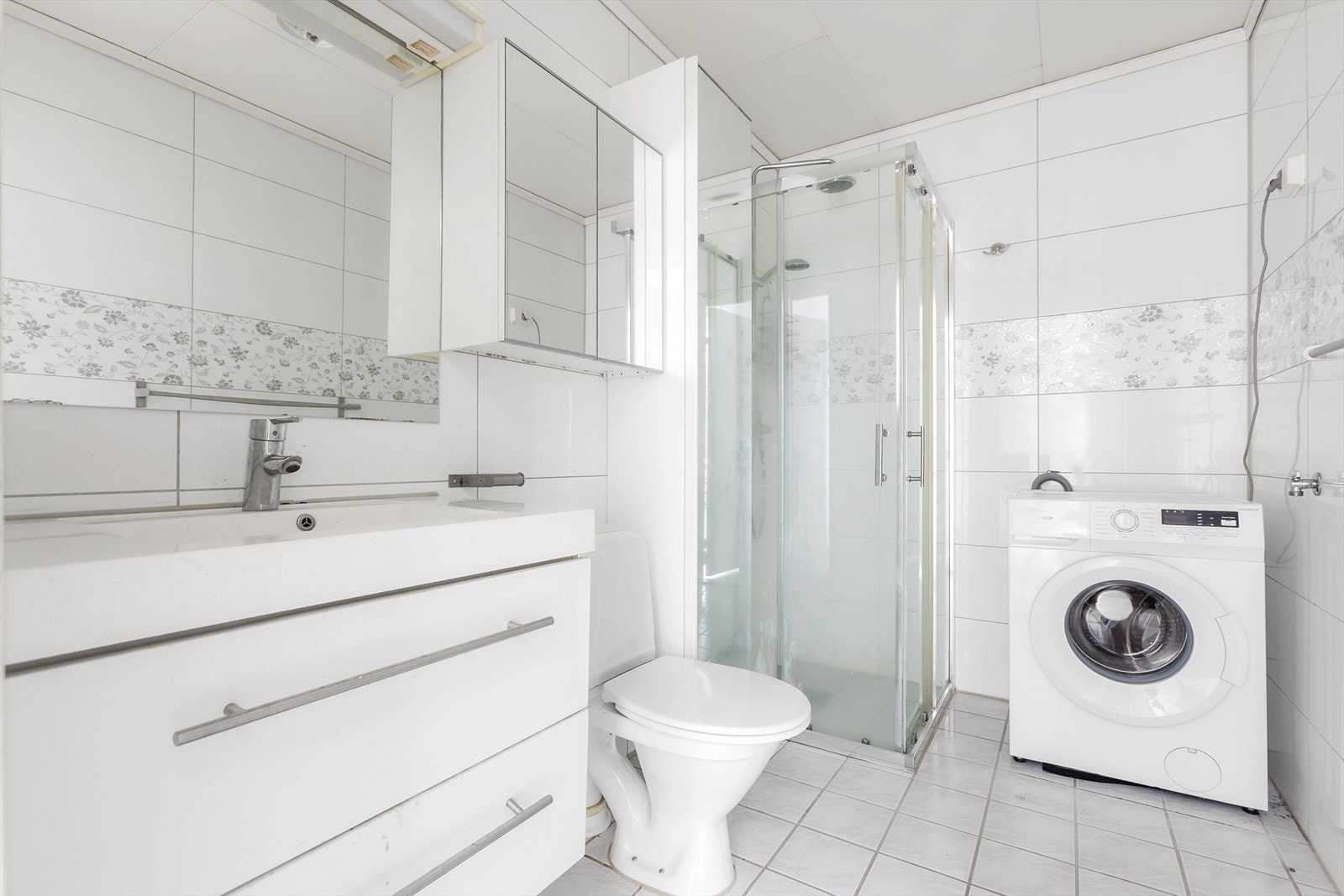 På badet er det flislagte overflater samt vannbåren varme i gulv. Godt med oppbevaringsplass i benkeskap, overskap og høyskap. Opplegg for vaskemaskin. Galleribilde