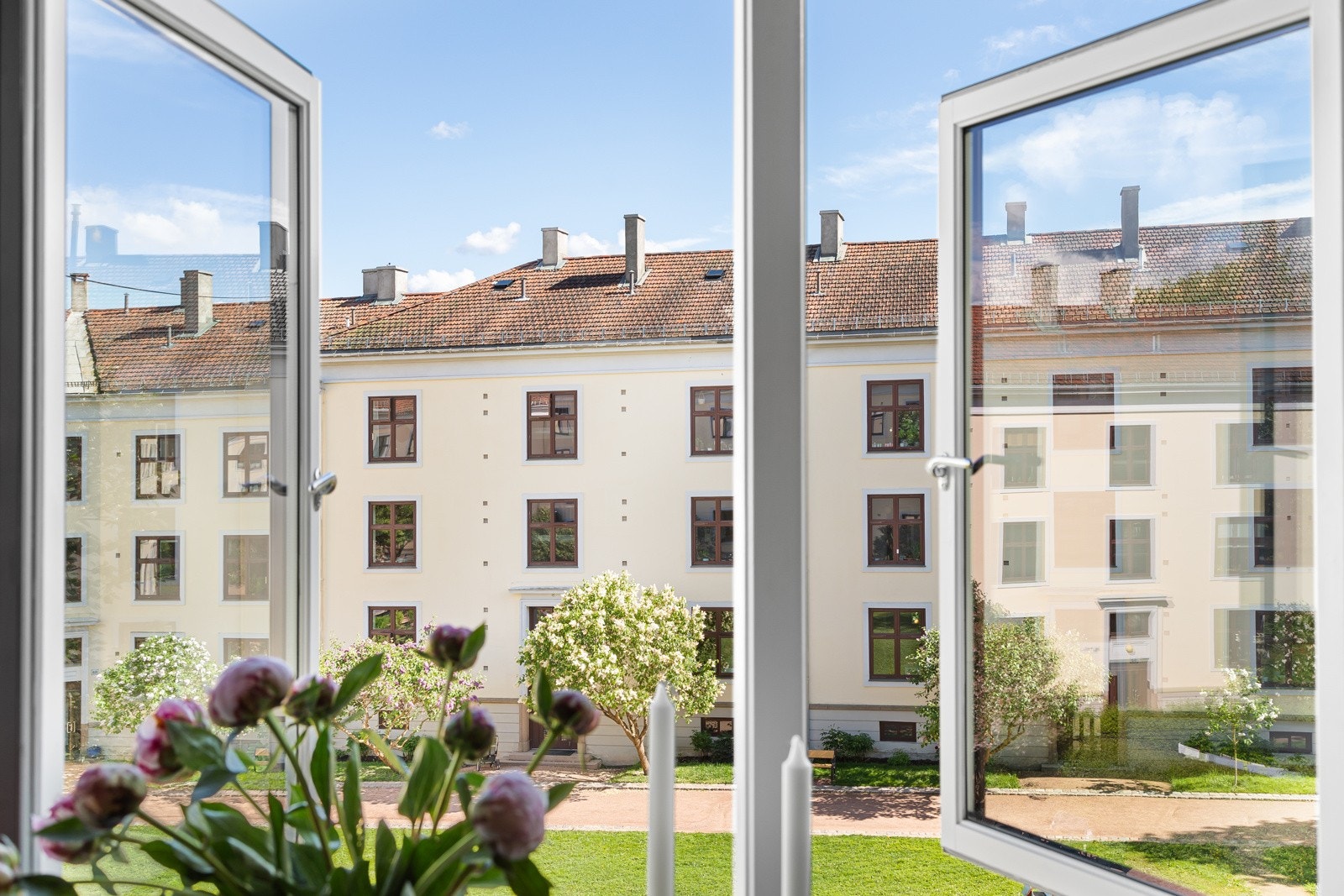 De store vinduene slipper inn mye naturlig lys og fantastisk utsyn over bakgården Galleribilde