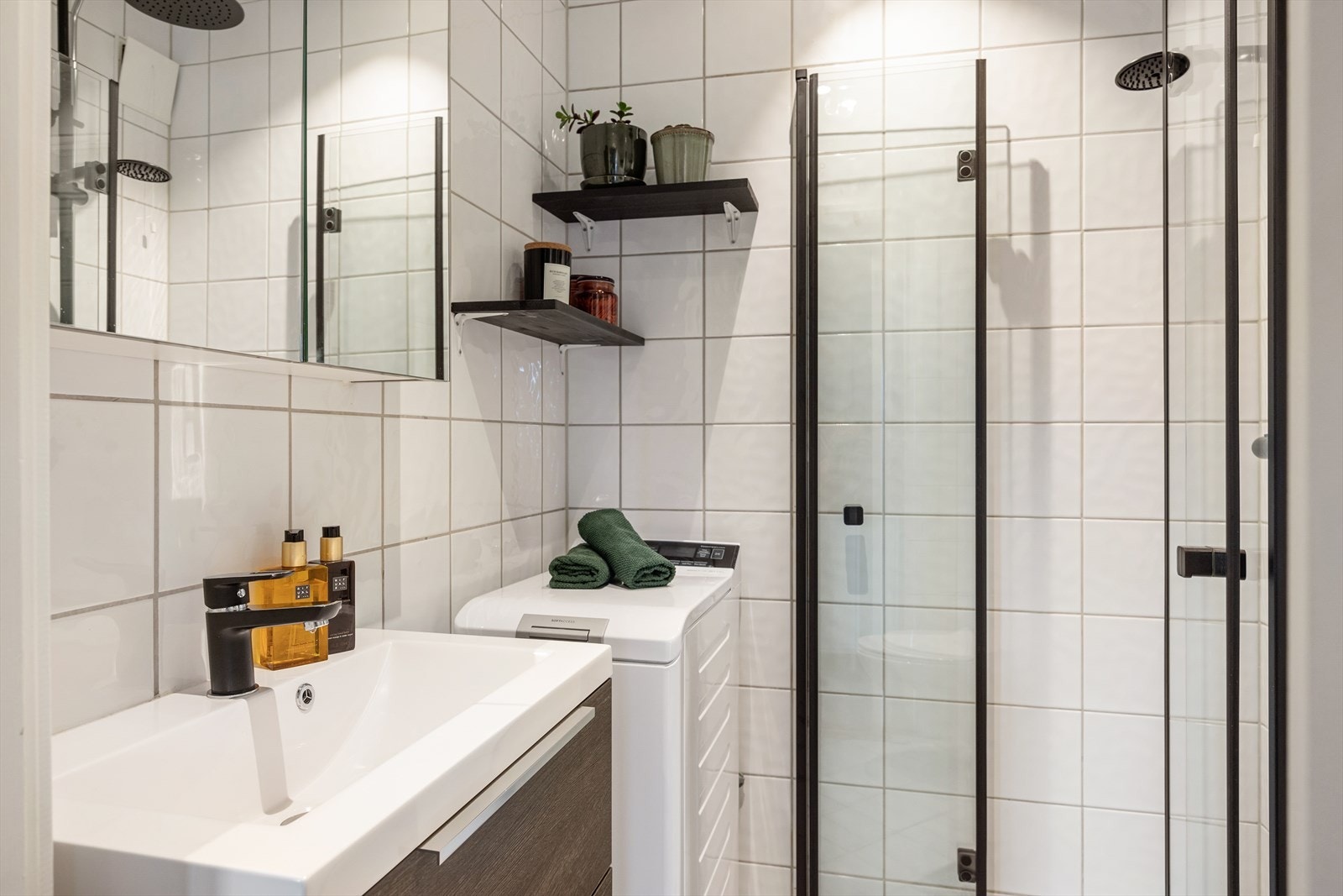 Badet består av servantskap med glatte folierte fronter, heldekkende servant, samt speilskap med lysarmatur på veggen over servanten. Det er opplegg for vaskemaskin. Galleribilde